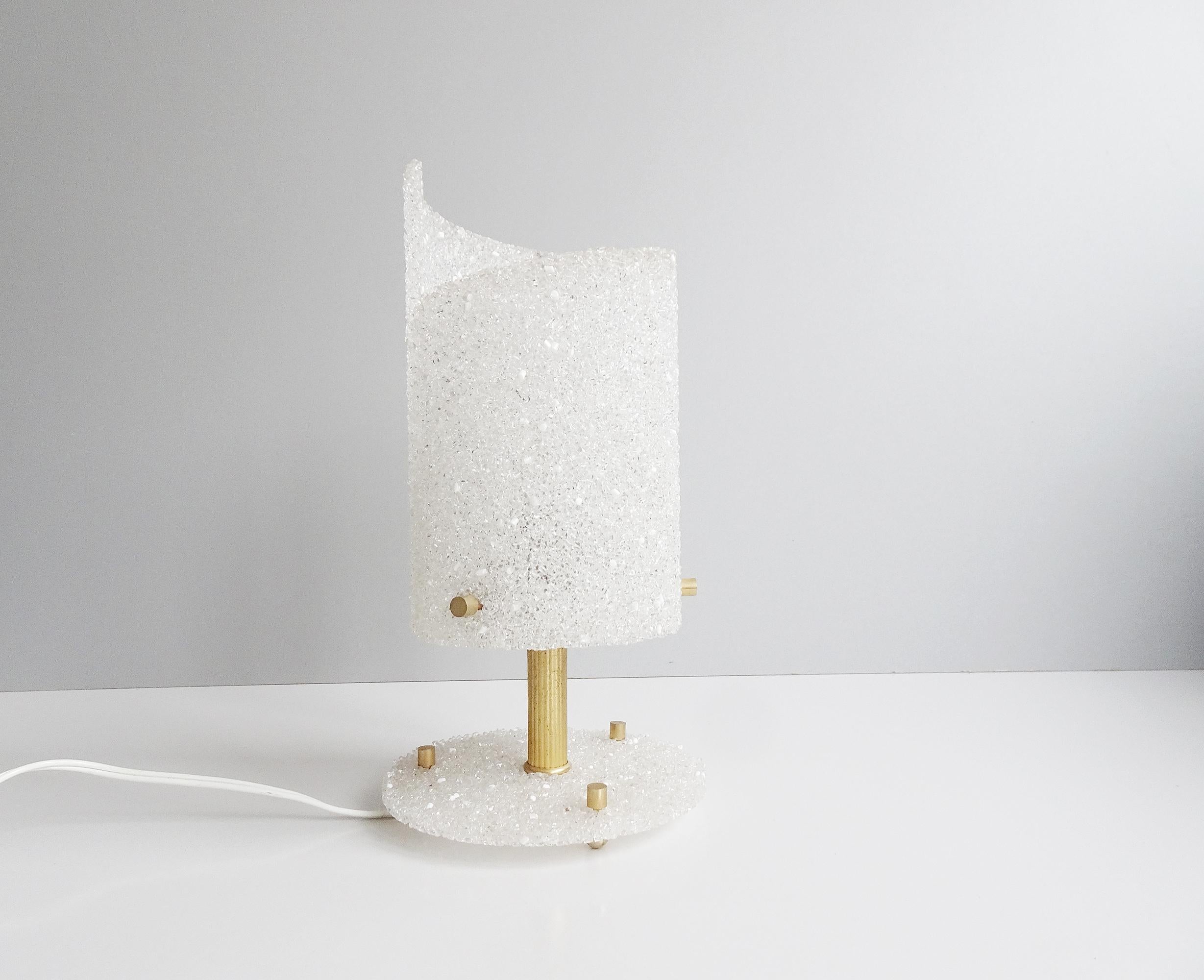 This French lamp is a noble table lamp from the 1960s. Shapely design made of resin with golden details made of metal. The granules create a great glitter effect depending on the incidence of light, as well as a particularly pleasant glow.

French