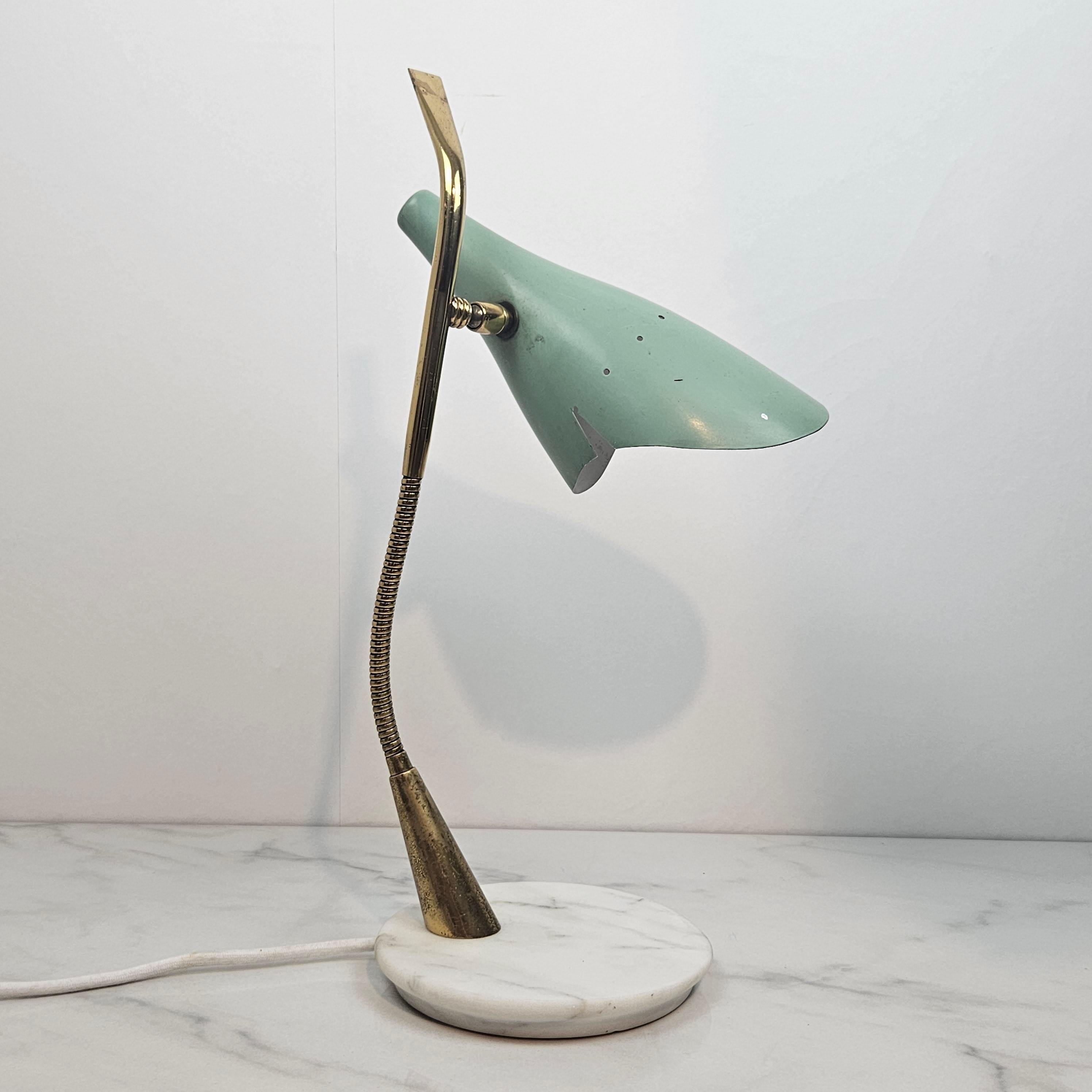 Italian Mid Century desk lighting at its best.

The Italian designer Oscar Torlasco created this beautiful table lamp for Lumi in the 1950's. 
The construction is made of brass and the base is made of marble. 
The adjustable reflector is made of
