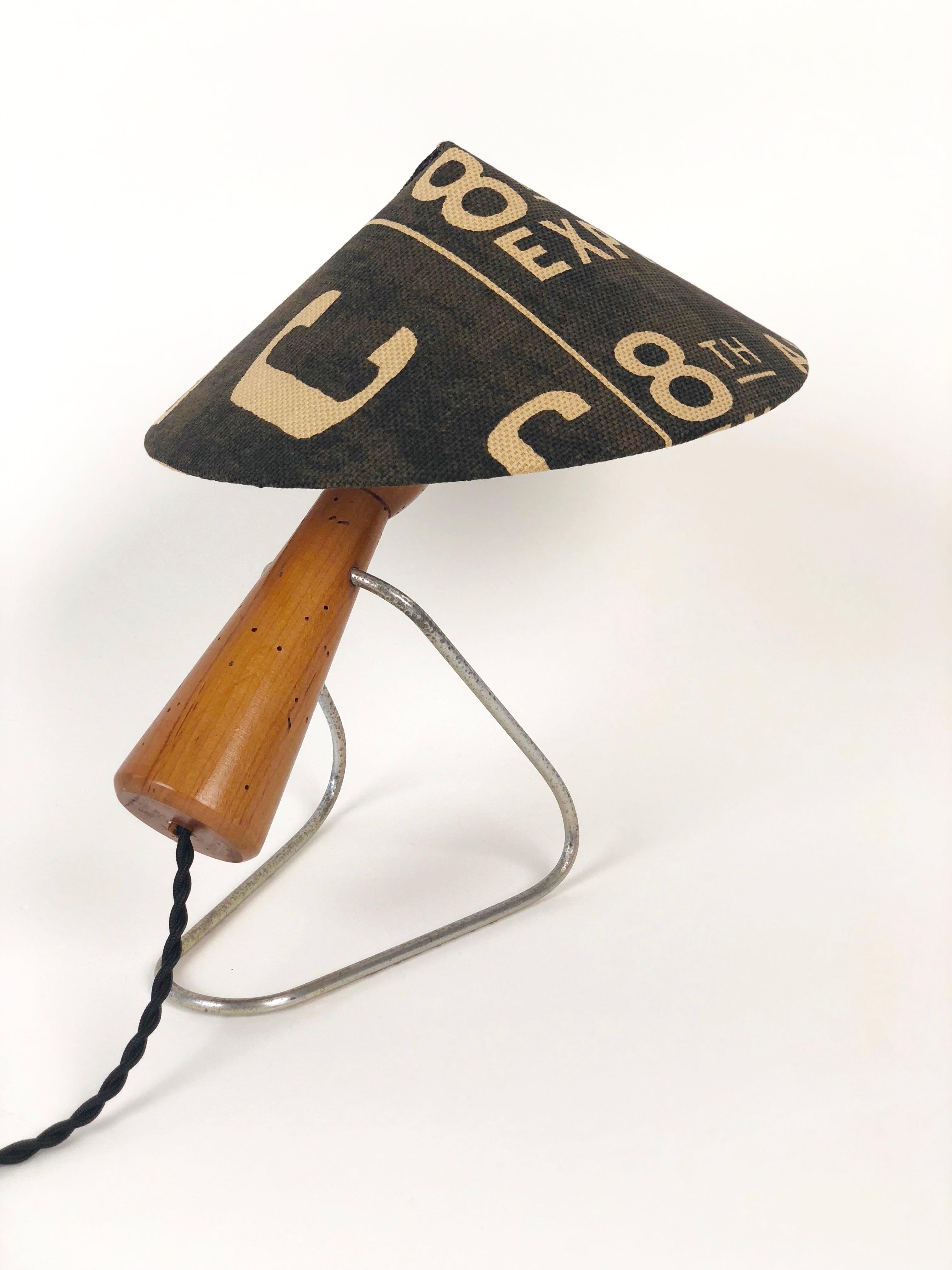 A playful midcentury table lamp in oak and metal. Produced in the early 1950s in Czechoslovakia, it has been rewired with a cloth covered 
cable and a new lampshade, covered Andrew Martin Linen. The wood is completely stabile, the worm holes are