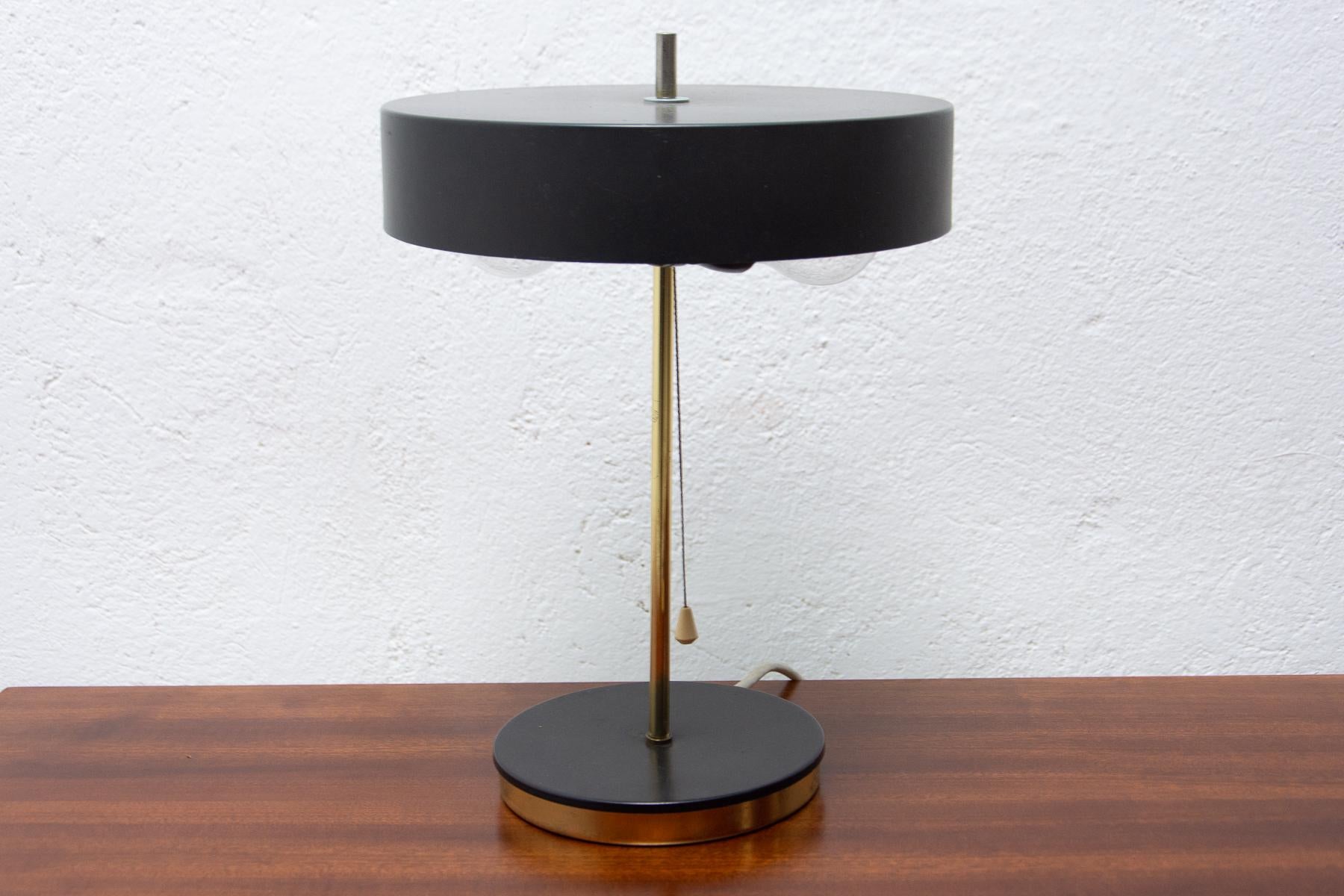 This mid-century table lamp was made in the former Czechoslovakia in the 1960s.
It is made of black plastic, brass and metal.

In very good original condition,

Works with two E27 bulb, UP to 250 V.

Measures: Height: 37 cm

width: 27