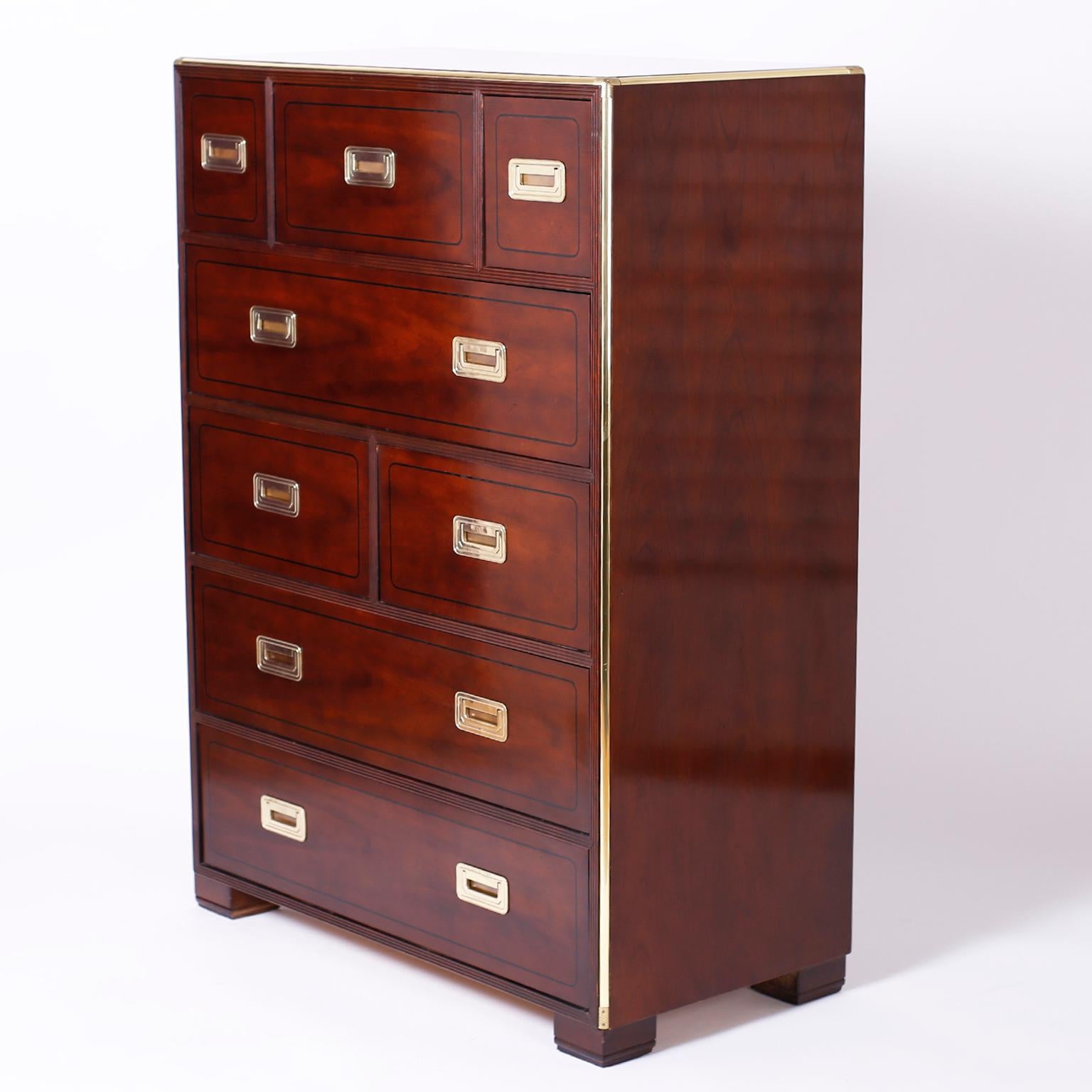 Campaign style chest of drawers or gentlemen's chest with eight drawers crafted in mahogany with a deep lush finish contrasted by brass hardware and piping on the corners. Signed Baker on a silver label in a drawer.