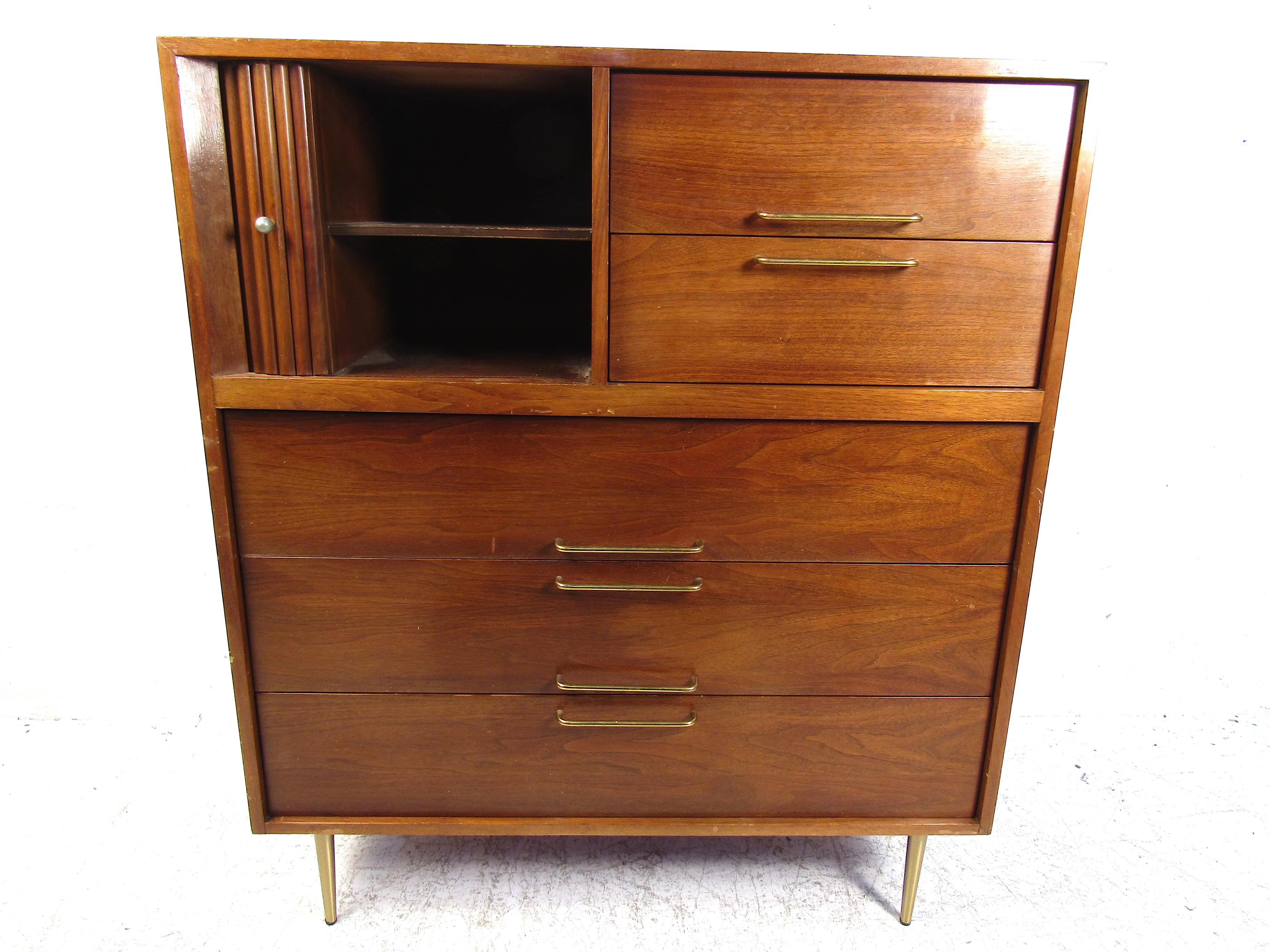 This beautiful midcentury dresser features a functional design and a bold aesthetic. It has sturdy brass covered legs that tie the whole look together. Perfect for any bedroom or guestroom. This piece features ample storage as well as a functional