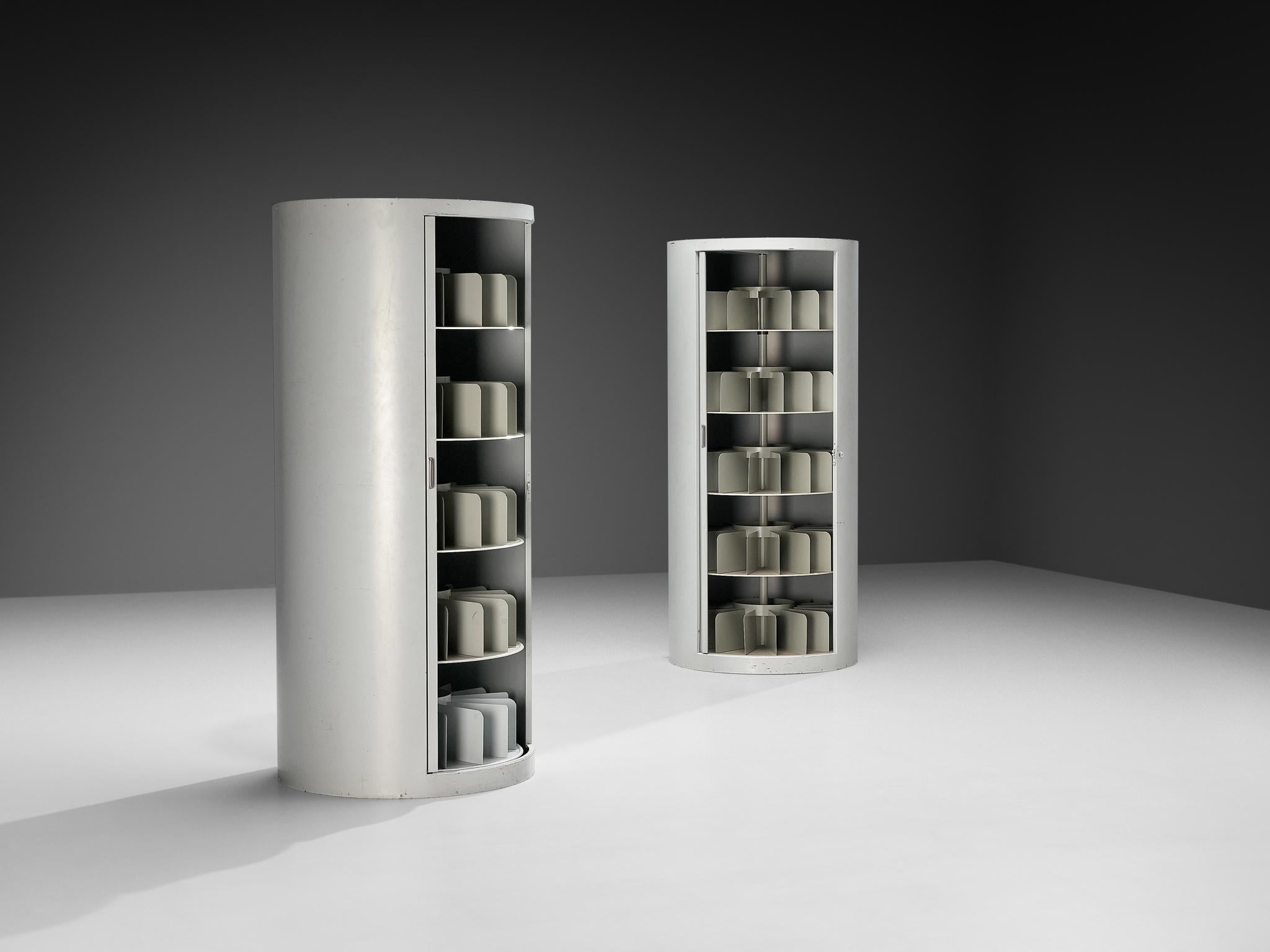 Filing cabinets, lacquered steel, metal, Germany, 1960s 

These filing cabinets from the 1960s are unusual because of their cylindrical shape. Instead of the usual boxy, rectangular form we expect from office storage, they stand like tall, rounded