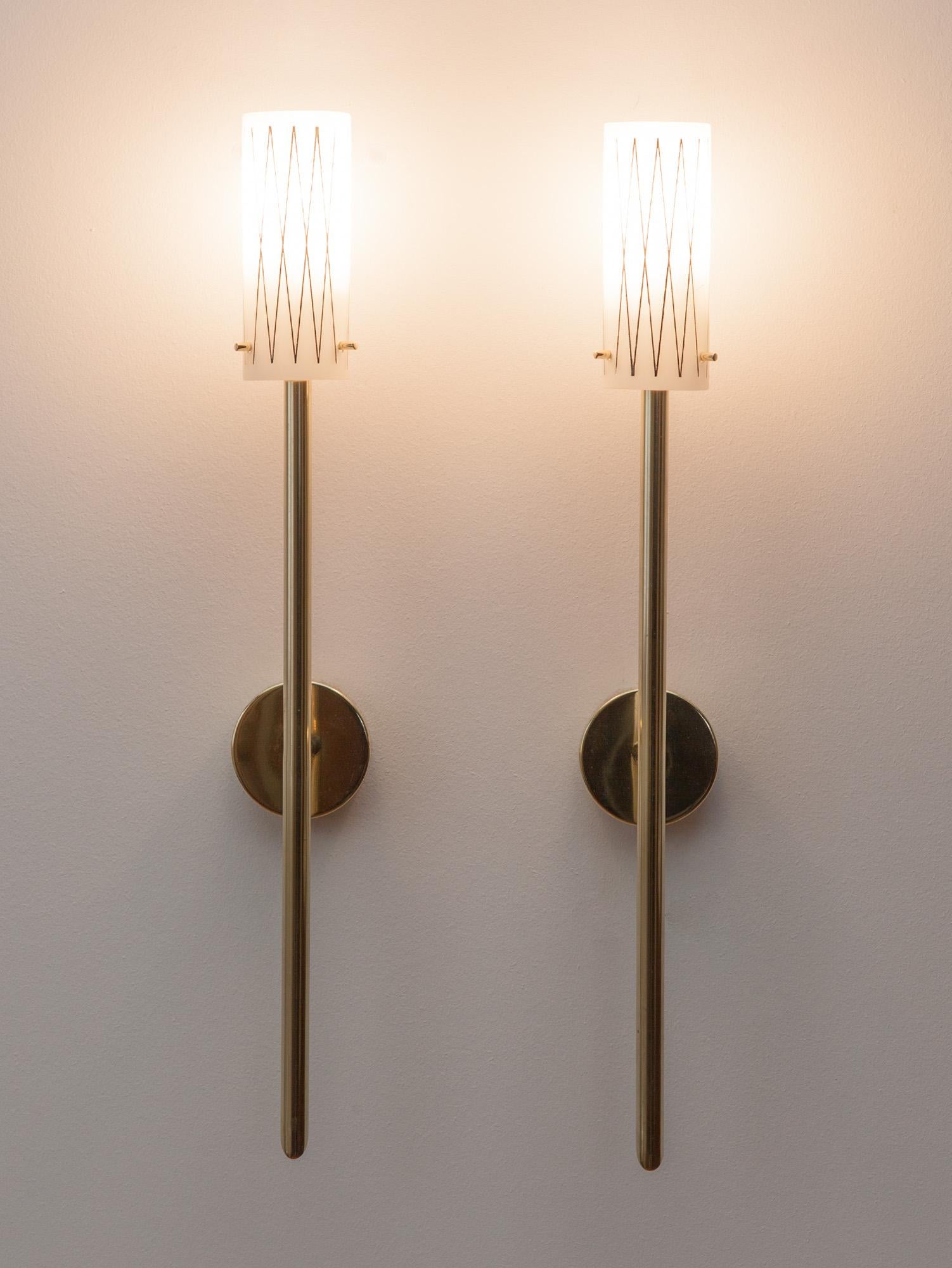 Tall and elegant Italian brass wall lights with glass shades. Crisp black geometric lines wrap around the milky white glass shade. Typical of Italian craftsmanship, attention to detail is seen throughout; from the beautifully machined brass pins,
