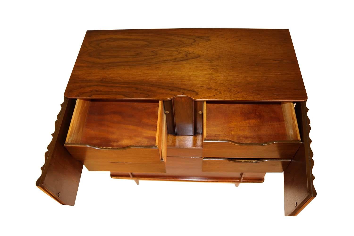 A remarkable midcentury highboy dresser by United in nearly pristine condition. Exceptional construction and style, features a unique set of sculpted double cabinet doors that open to reveal four drawers, constructed out of rich walnut, having seven