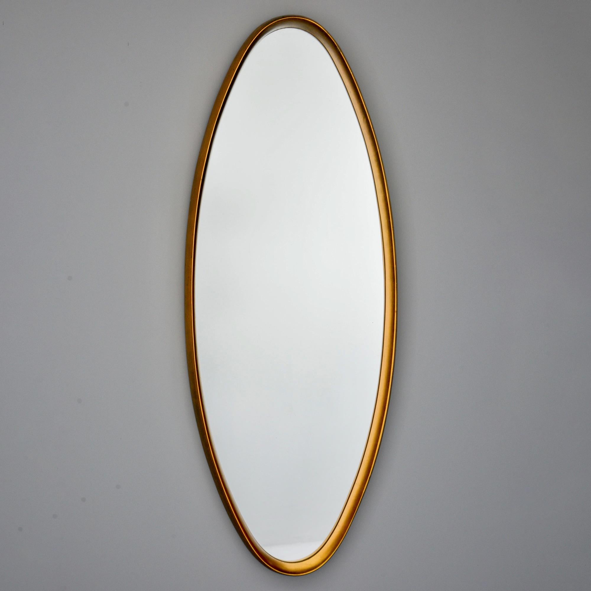 Tall narrow oval mirror with slim, deep set giltwood frame circa 1960s. Unknown maker.
  