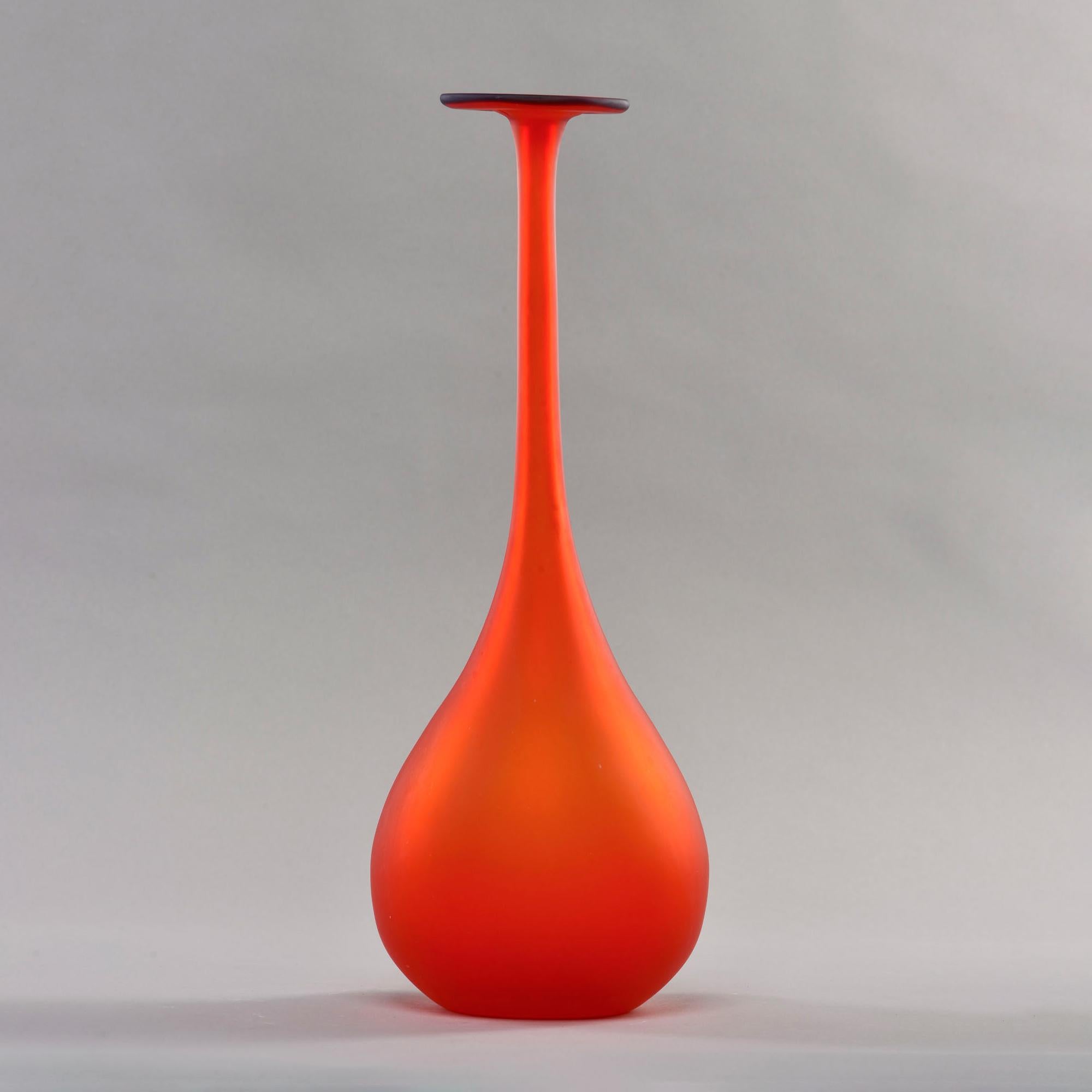Circa 1960s Murano vase in red satin glass features a tall, slender neck accented with a wide, flat lip in deep cobalt blue. No signature found. Unknown maker.

Very good vintage condition with minor scattered surface wear. No flaws found.
 