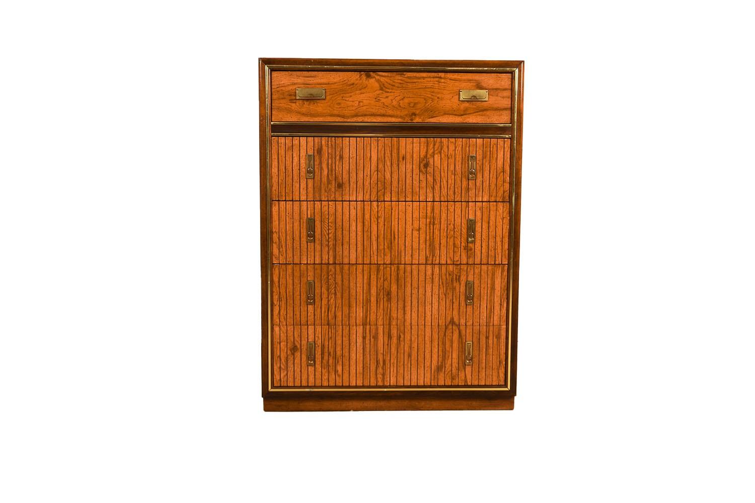 An elegant mid-century tallboy dresser. This is a beautiful example of Mid-Century craftsmanship. This retro piece was constructed with top of the line hardware, and excellently crafted woodwork. Features solid hardwood, with a two-tone walnut