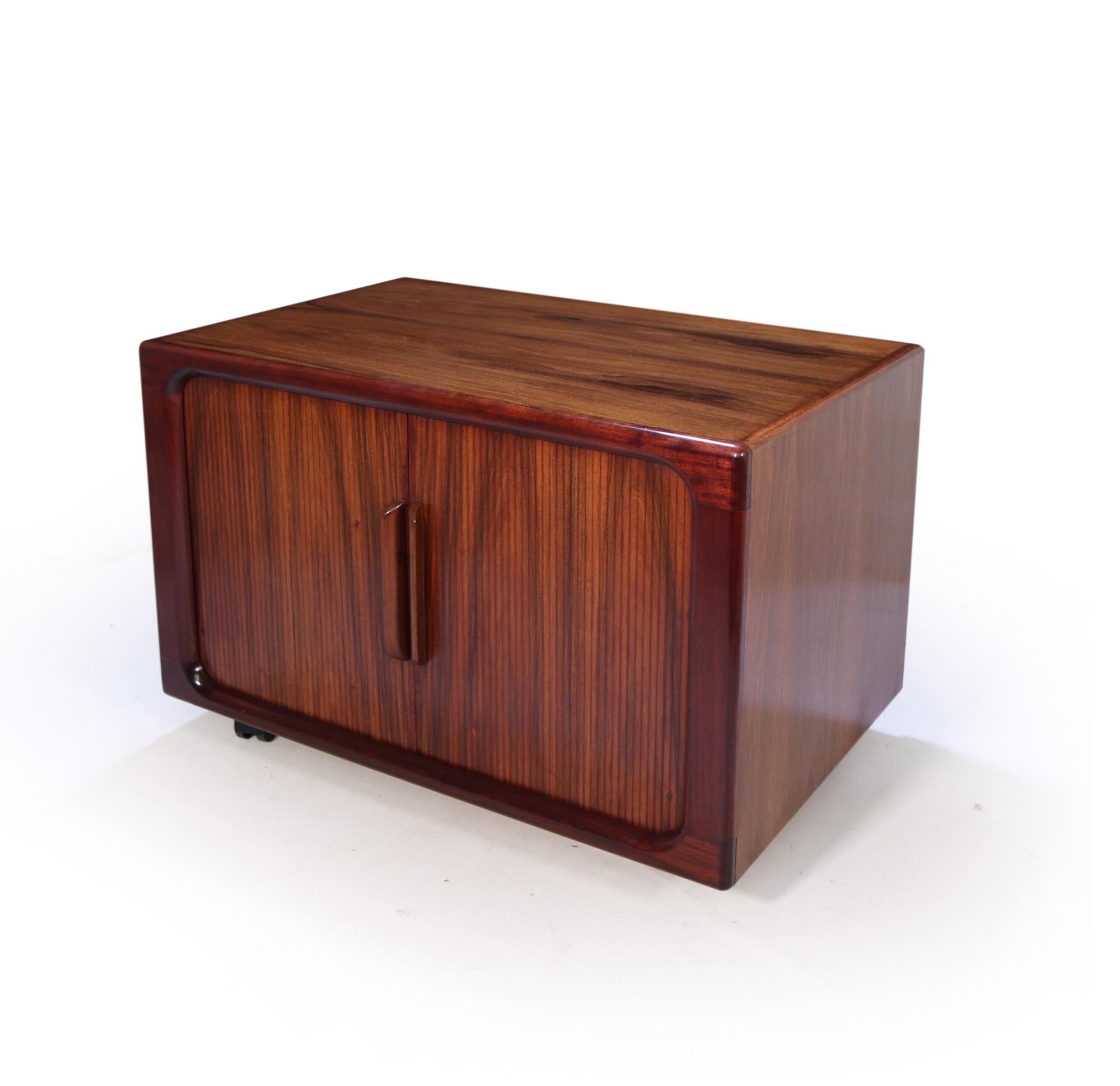 A small good looking santos rosewood tambour door media sideboard produced in the 1960’s by Dyrlund, the tambour doors open to reveal sliding shelves behind, original factory hole in back for wires, the cabinet has been restored where necessary and