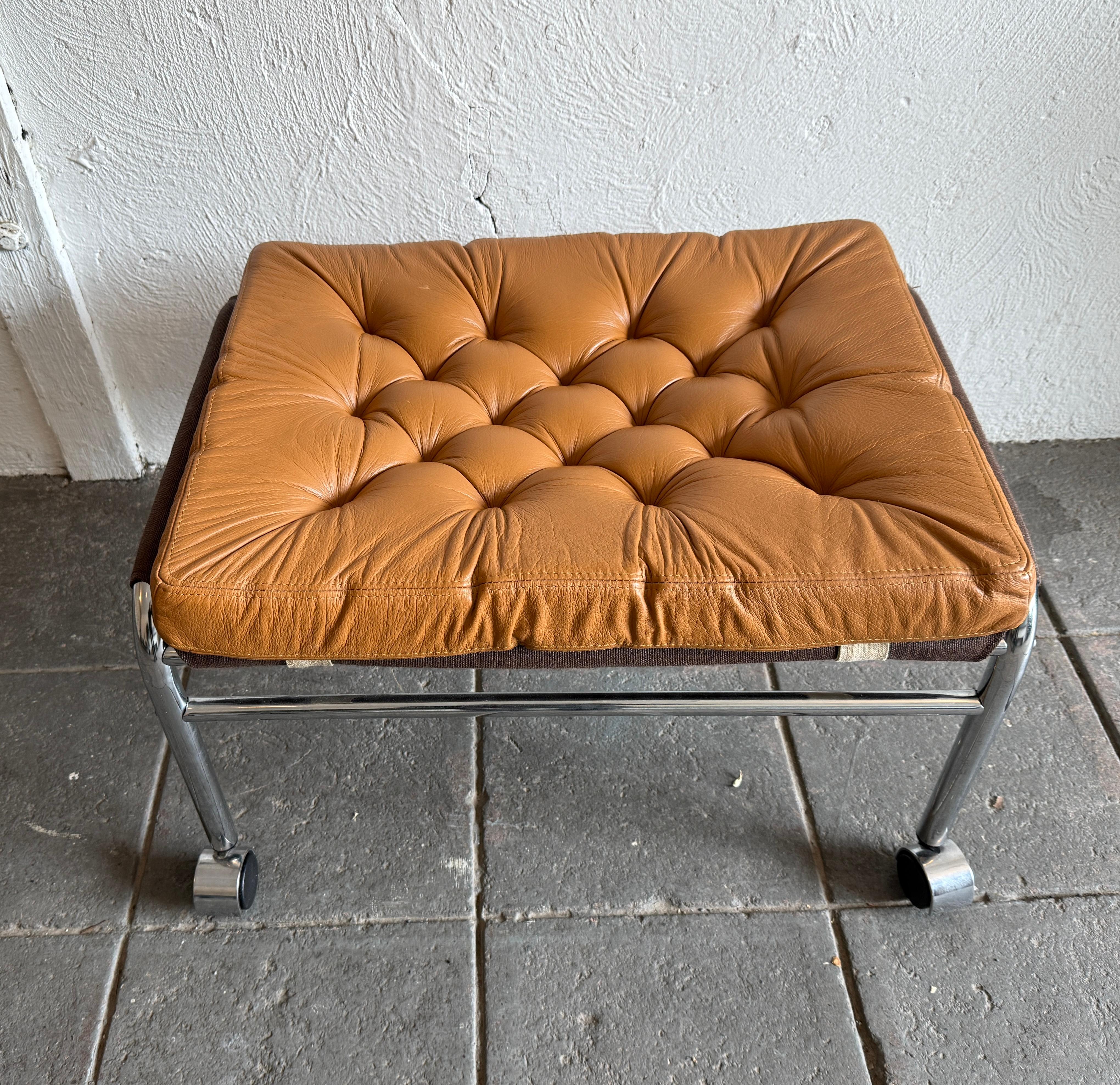 Post Modern Tan Leather tufted chrome stool, bench, footstool or ottoman with casters. Conçu par Bruno Mathsson pour DUX. Tabouret, banc ou ottoman avec un coussin en cuir et un cadre en tube chromé qui repose sur (4) roulettes. Très propre, avec