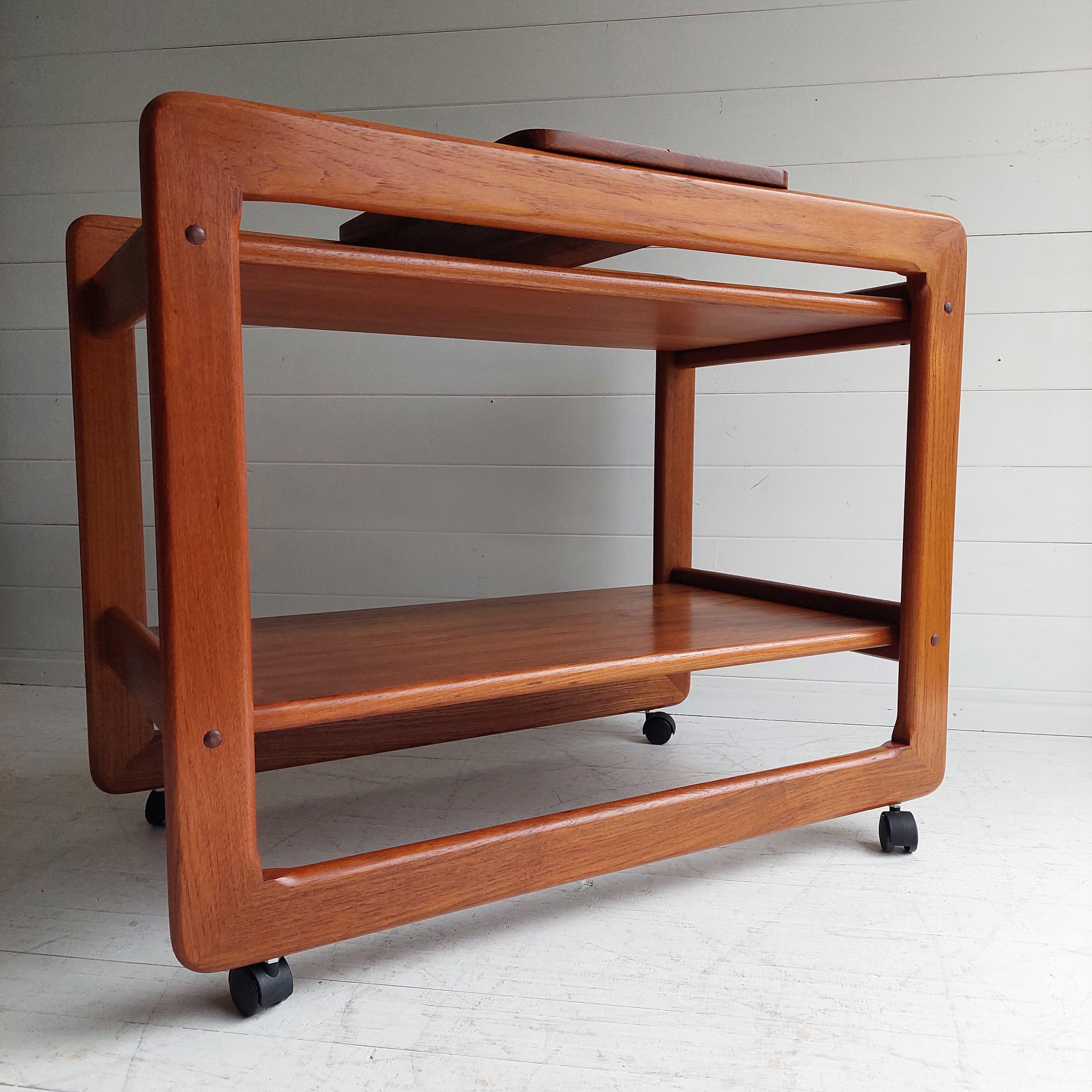 Midcentury Tarm stole Og Møbelfabrik Danish modern teak bar cart.
Circa 1970s
Very nice trolley made of solid teak on castors.

2 tier drinks trolley which has a cheese board that fits on the upper frame.
Stunning Danish design with amazing