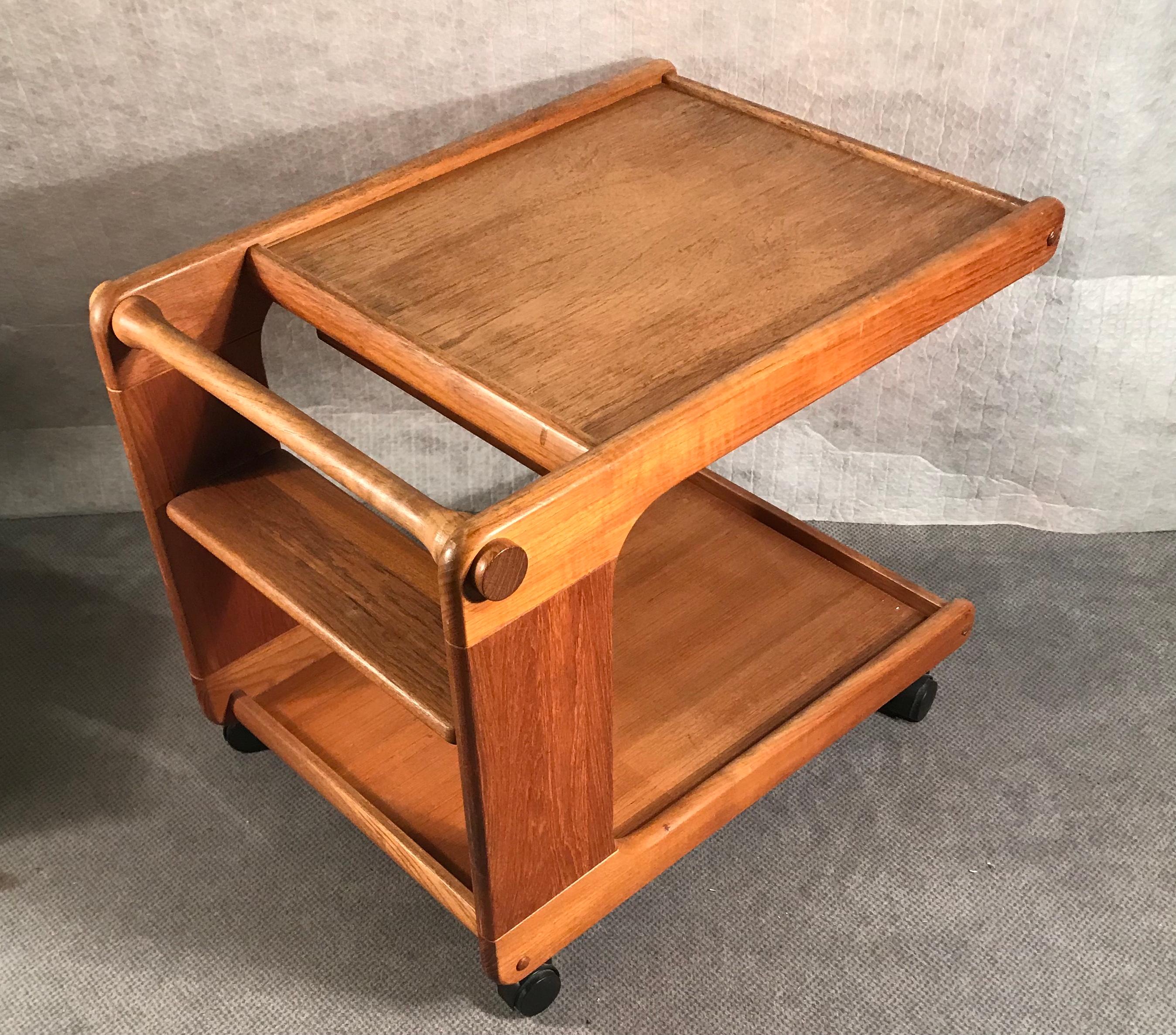 Mid Century tea or bar cart, Denmark, 1960's. Teak wood.
The bar cart stands on four black casters. It has two shelves. the upper shelf has a pull out tray, which is removable. The bar cart is in very good vintage condition.
  