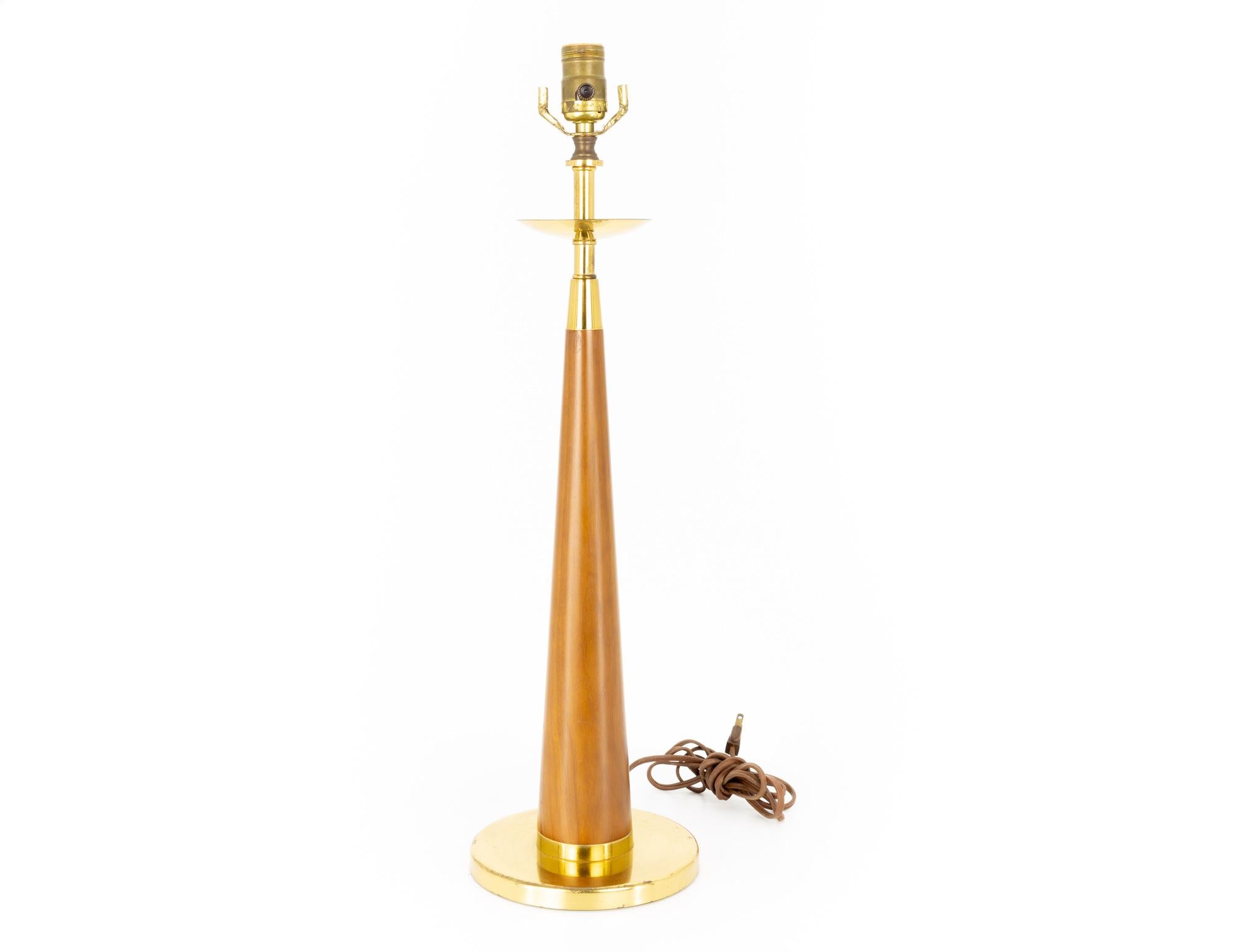 Mid-century teak and brass cone shaped table lamp.

This lamp measures: 7 wide x 7 deep x 24.5 inches high.

This lamp is in great vintage condition with some minor marks, dents, and wear.

We take our photos in a controlled lighting studio to