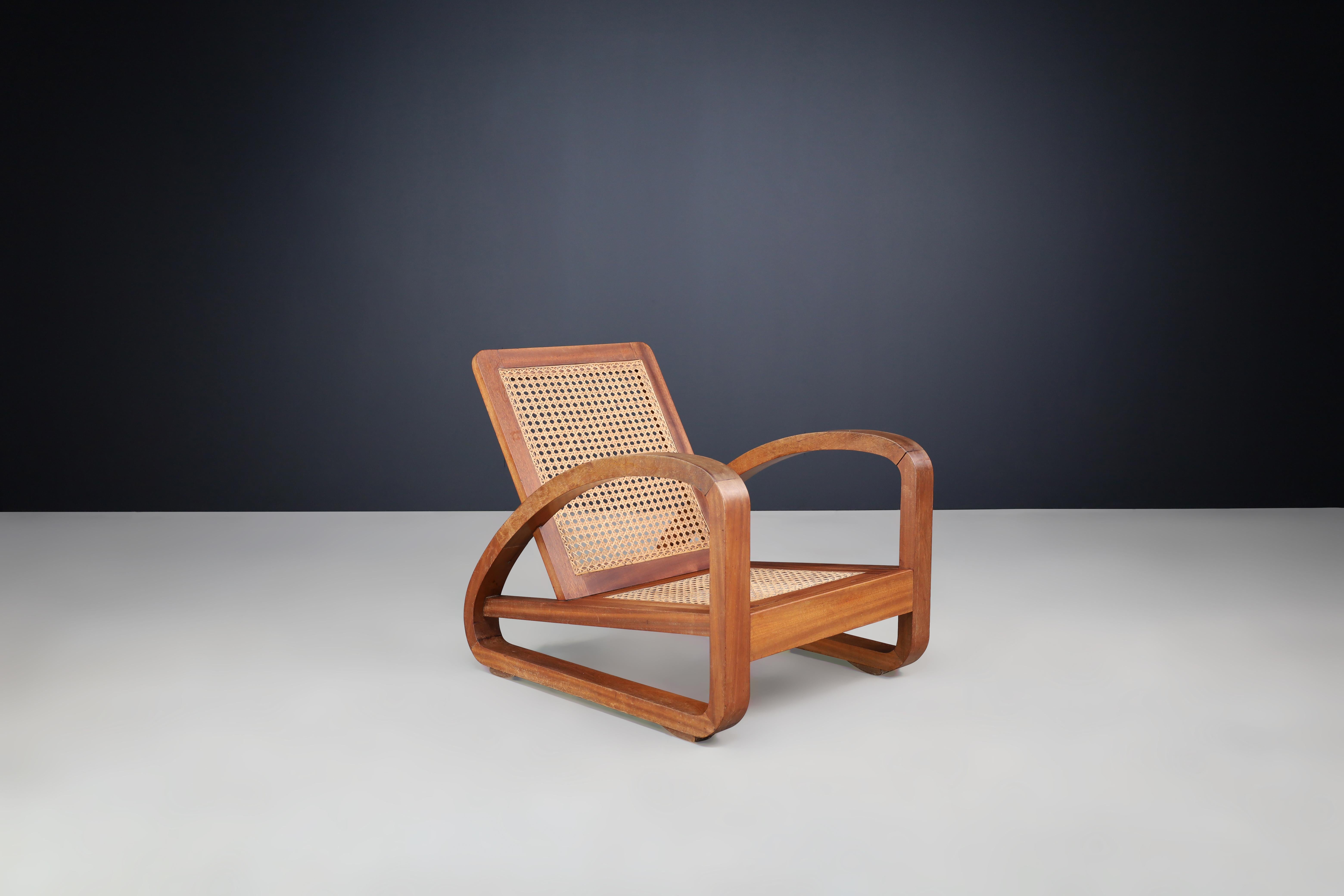 Mid-Century Teak and Cane Lounge Chair from France, 1950s

This exceptional mid-century French lounge chair beautifully marries striking structural design with meticulous craftsmanship, capturing the essence of a transformative era in design.
