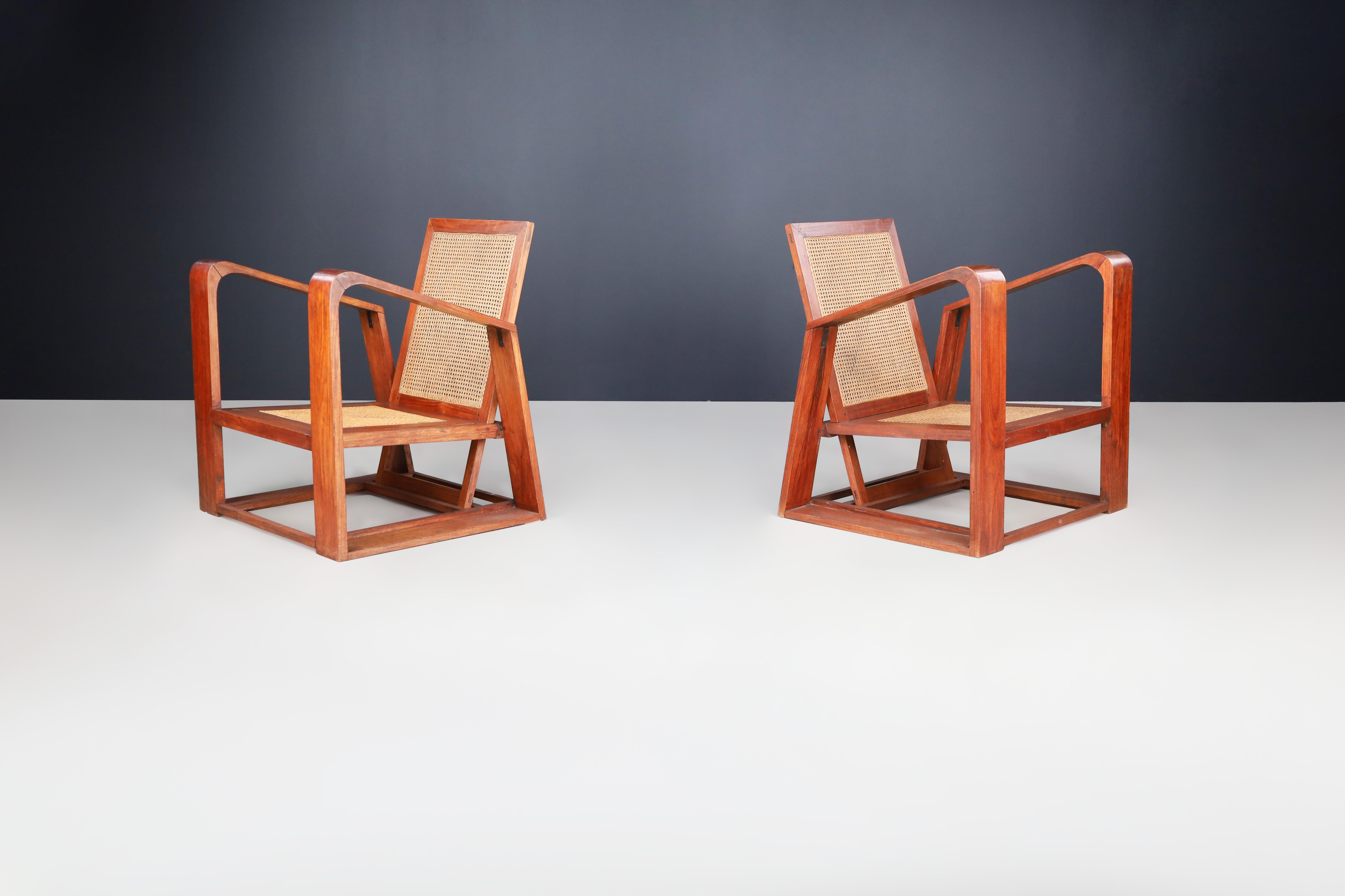 Mid-Century Teak and Cane Lounge Chairs from France, 1950s

These mid-century French armchairs combine visually stunning structural design, expert caning techniques, and high-quality materials. The chair's angles are visually striking, reminiscent