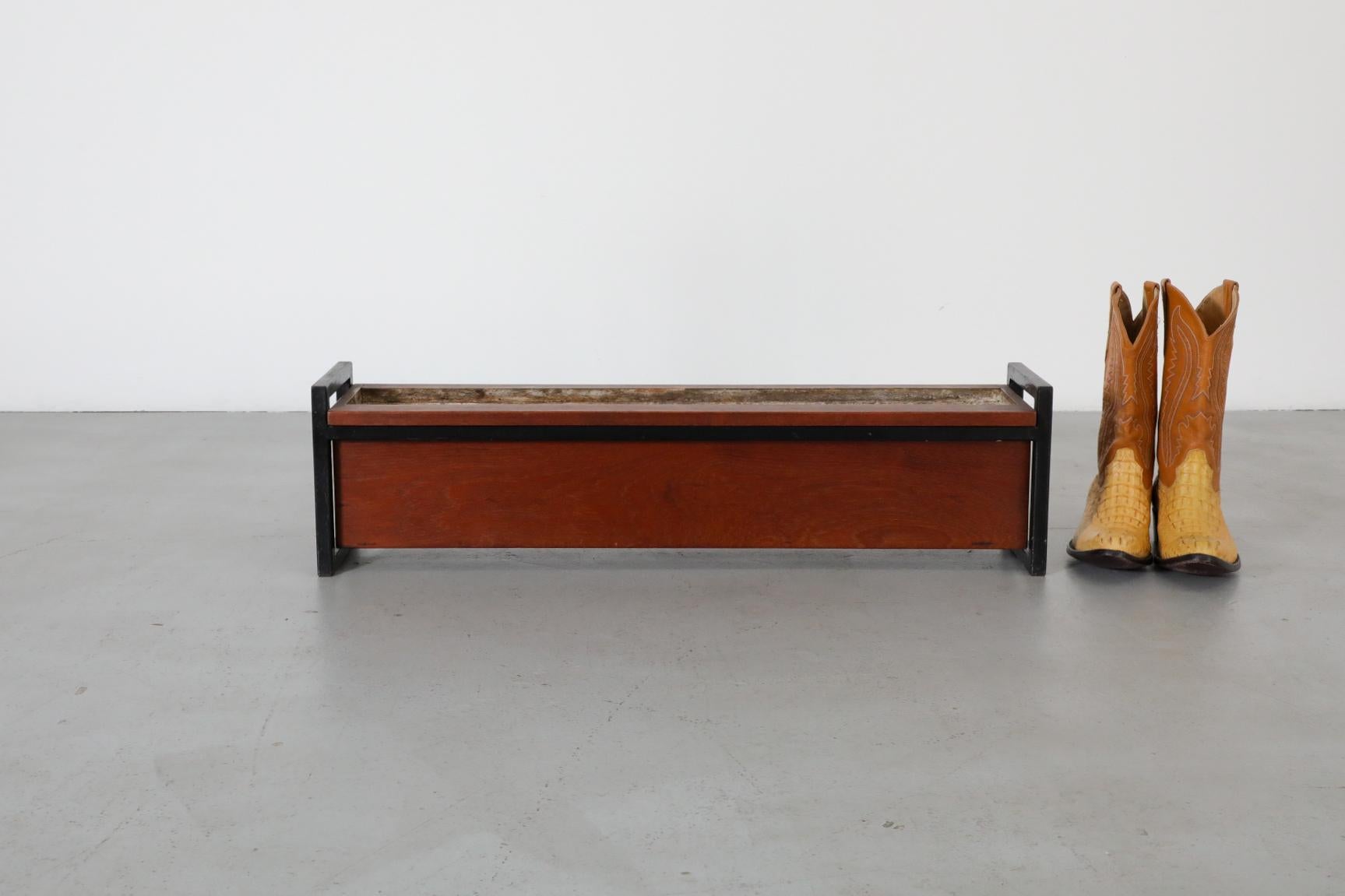 Fioriera di metà secolo in teak con struttura in acciaio smaltato nero e inserto in latta. In condizioni originali, con segni visibili di usura dovuti all'età e all'uso.