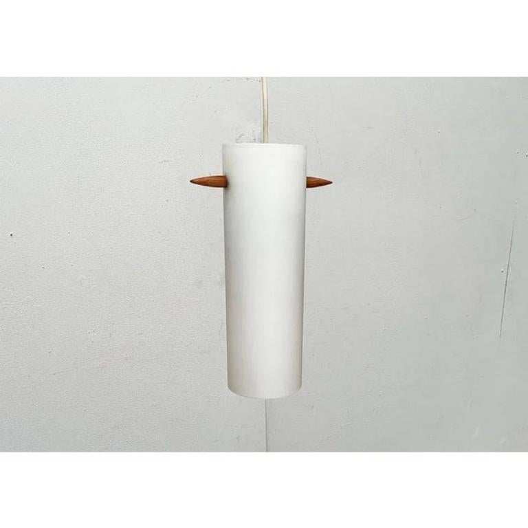 Rare glass pendant lamp from the swedish manufacturer luxury according to a design by uno and east kristansson from the 1960s.

An elegant design of special materiality. A simple glass cylinder forms the luminaire body. The peculiarity lies in the