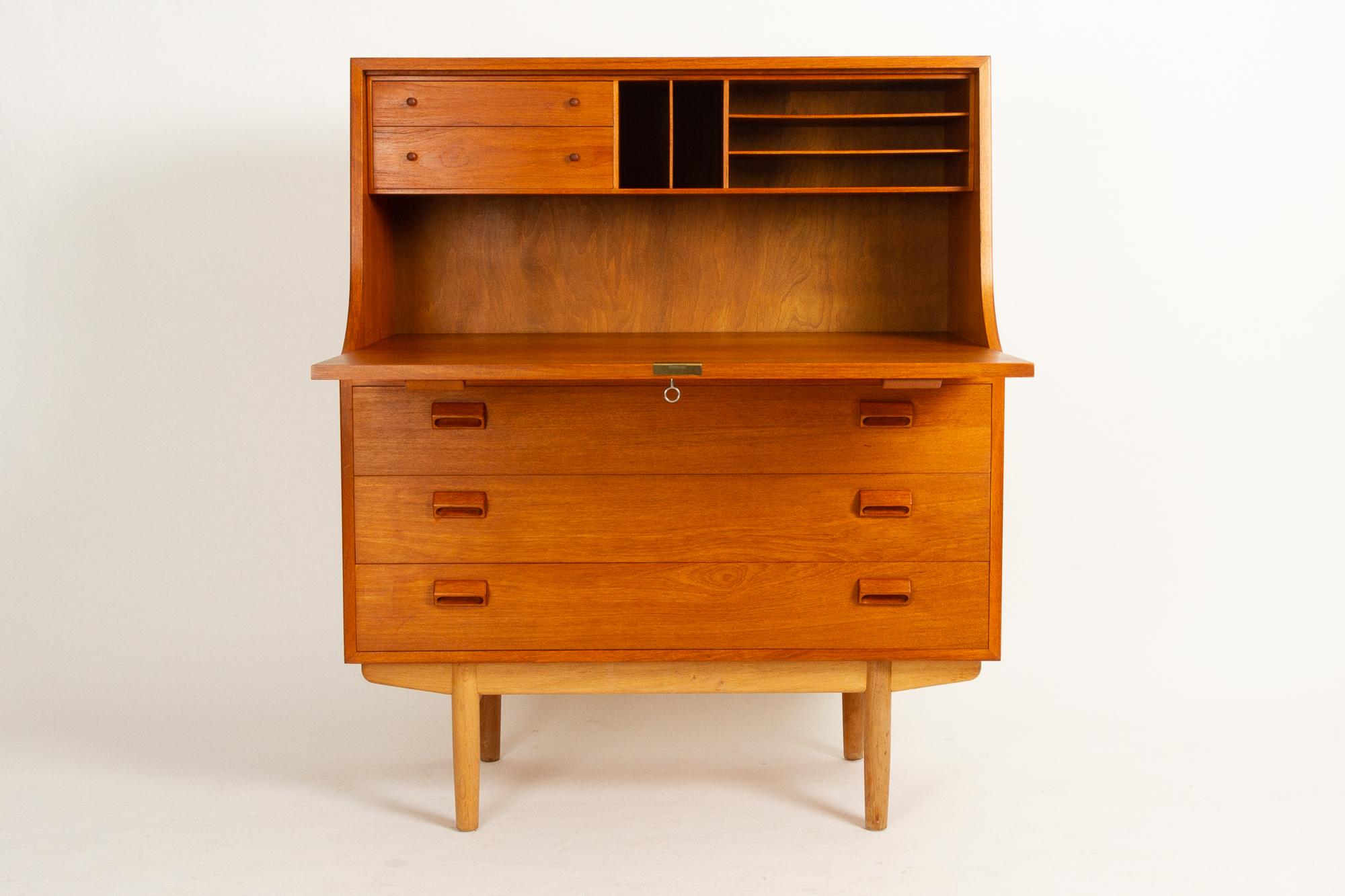 Midcentury teak and oak Secretaire by Børge Mogensen for Søborg Møbelfabrik, 1960s.
Large teak secretary with legs in solid oak. Drop down front. Large desk area. Two small drawers and five open compartments above the desk area. Underneath is three