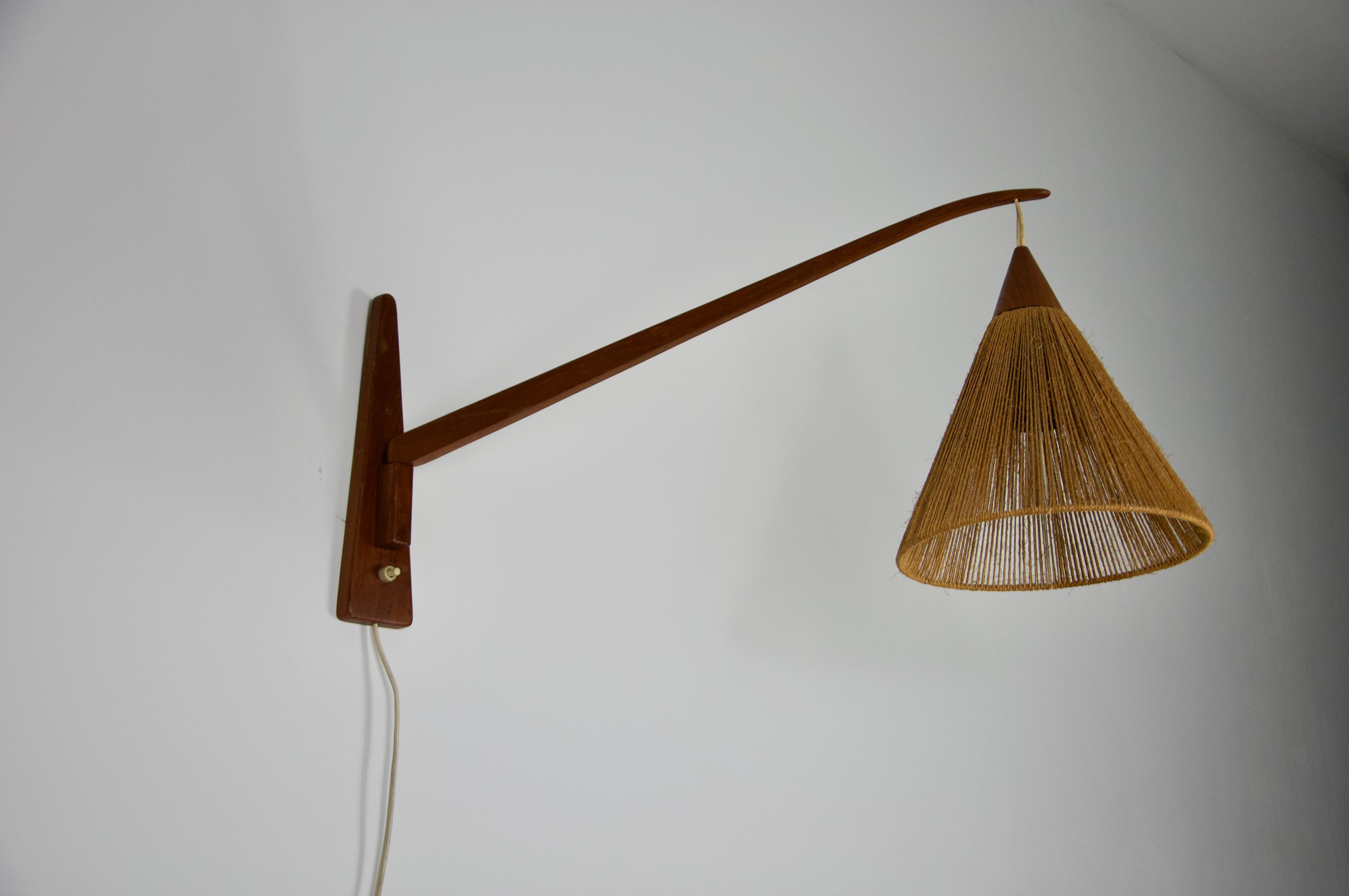 Questa splendida lampada da parete del produttore svizzero Temde degli anni '60 mette in mostra la bellezza senza tempo del design di metà secolo. Realizzata in teak di alta qualità, la lampada presenta un elegante braccio allungato con una finitura