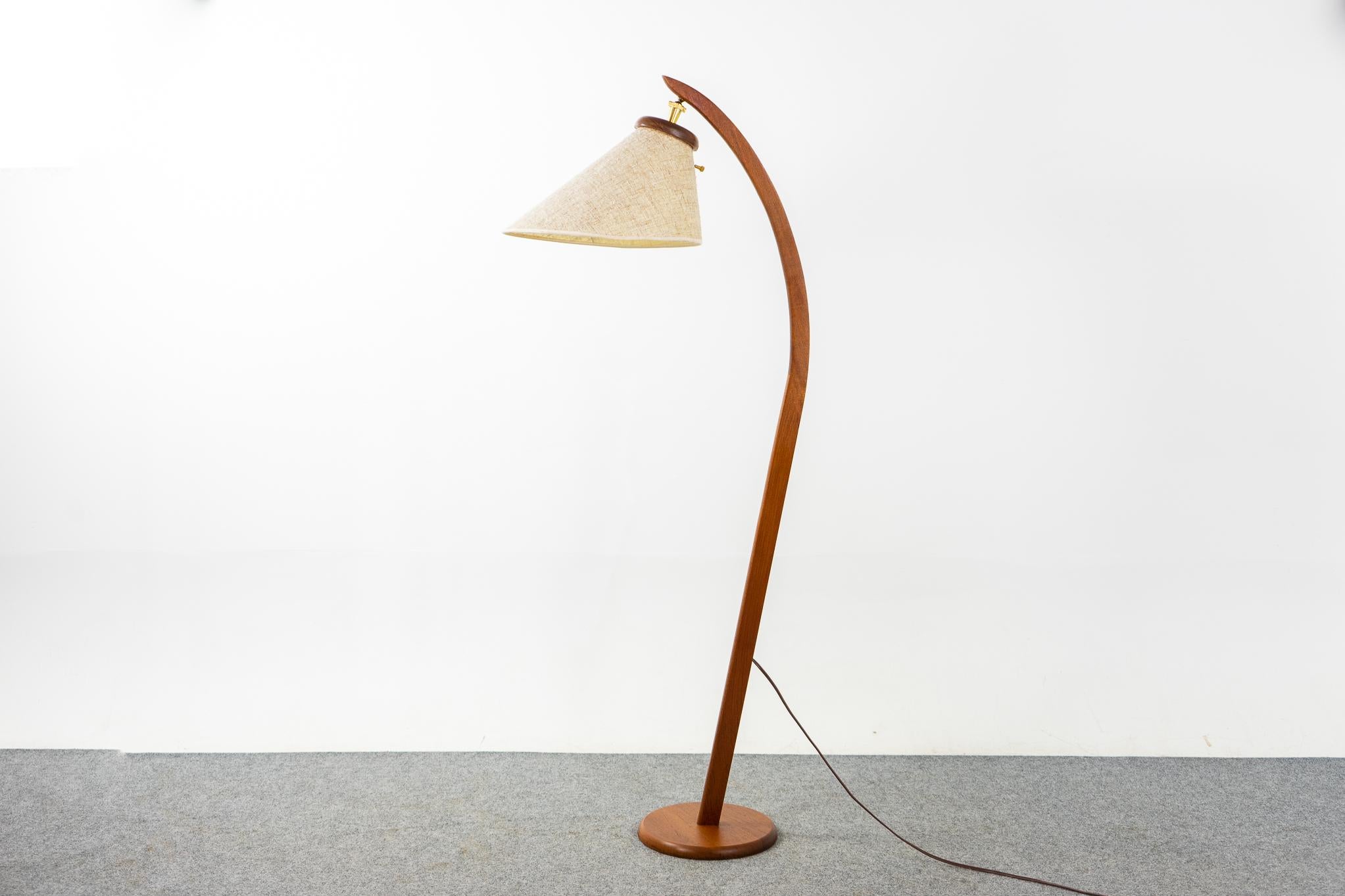Teak arc floor lamp, circa 1960's. Sought after sleek, graceful solid teak lamp with original textured Dutch bonnet adjustable shade, pivot the position to suit your needs! Tri-light socket offers 3 lighting settings. Back of shade shows minor