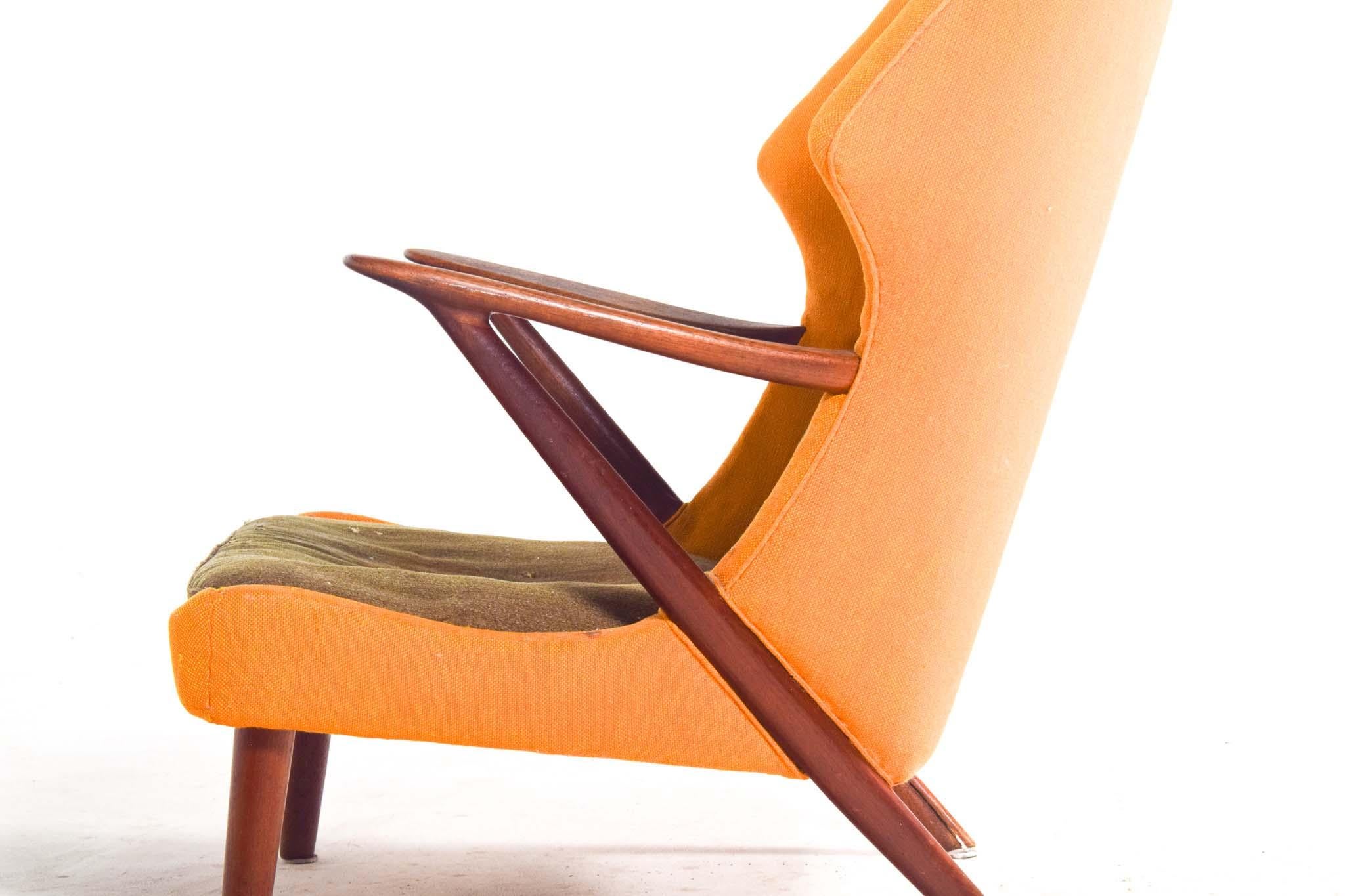 Questa poltrona Modello 221 del 1955 di Kurt Olsen per Slagelse Mobelvaerk incarna l'eleganza e la funzionalità del Mid-Century. Realizzata in teak massiccio, la sua struttura scultorea presenta braccioli graziosamente curvati e gambe angolate,