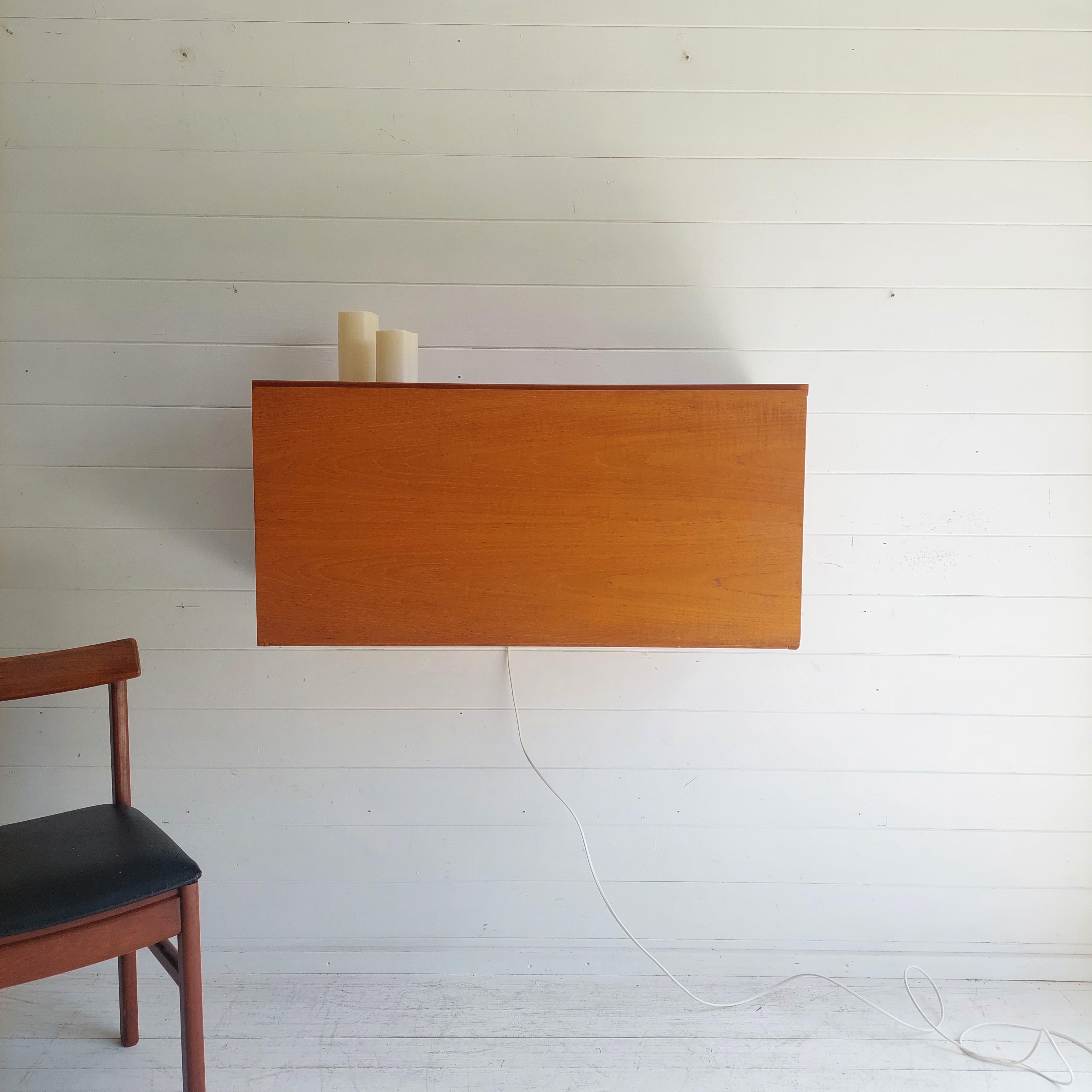 A Beaver & Tapley teak illuminated floating wall mounted desk storage unit, from their ’33’ range. 
Beaver & Tapley pioneered wall fixed floating units that did away with supporting frameworks. 
Designed by the world renowned Robert Heritage.
Very