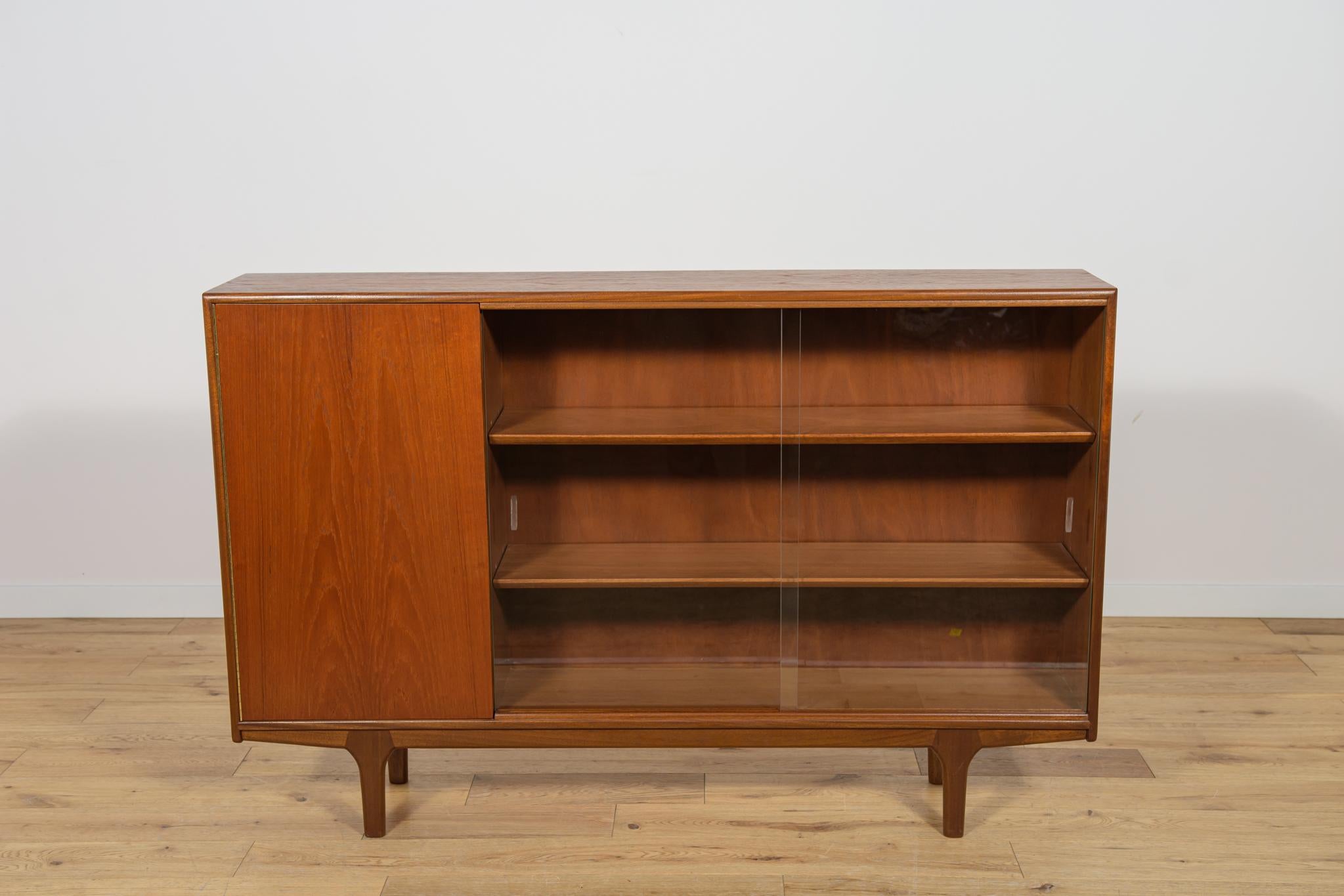 This Mid-Century bookcase in rosewood was produced in Great Britain by Mcintosh in the 1960s. The teak elements have been cleaned and polished with very quality Danish  Oil. Glass in perfect condition.