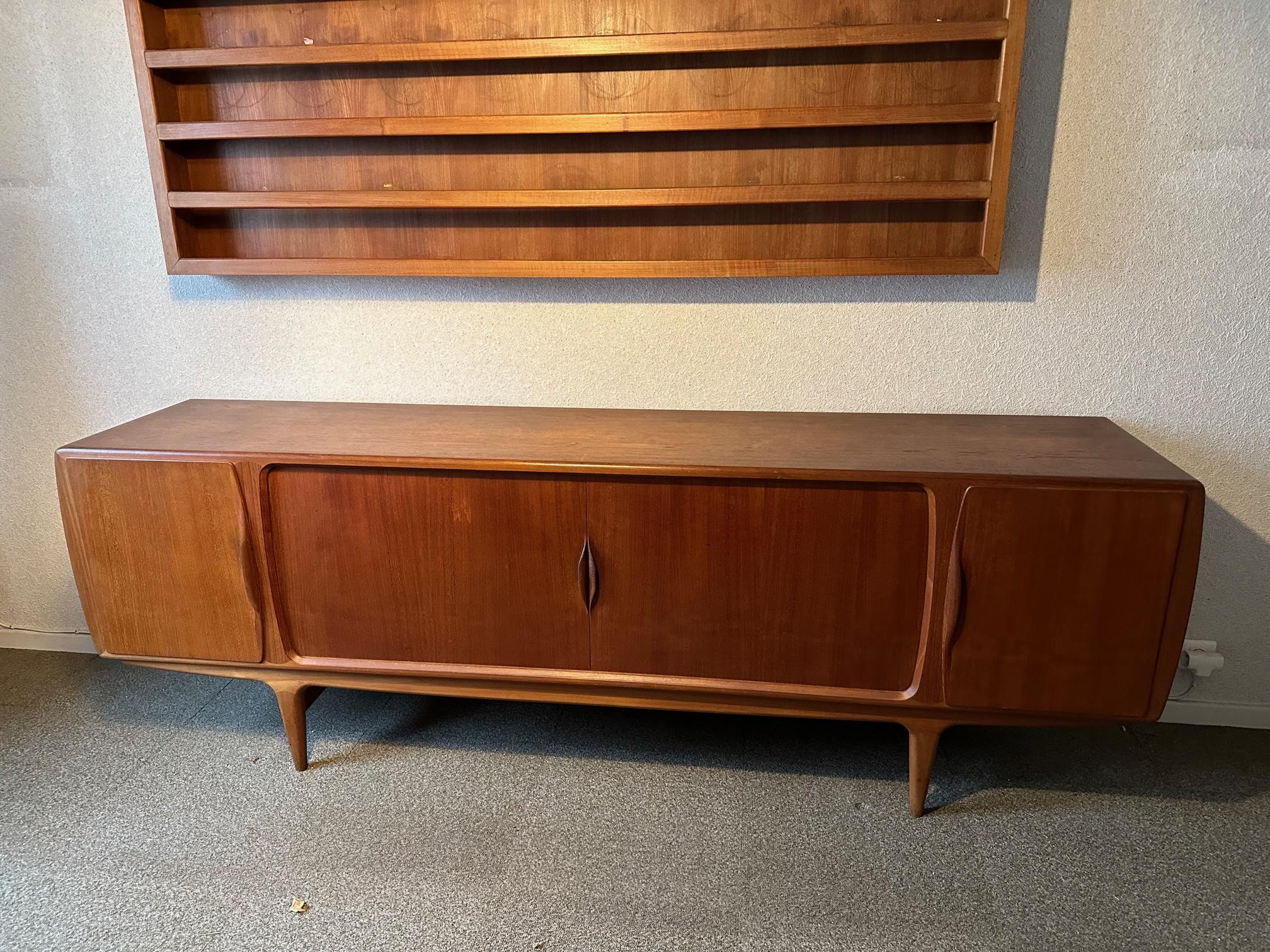 Very beautiful and elegant teak sideboard from the 60s by Johannes Andersen, Danish designer.
Very good state. Two peripheral doors and two central sliding curtains.
Three central drawers and numerous modular shelves.
Slightly rounded sides. Very