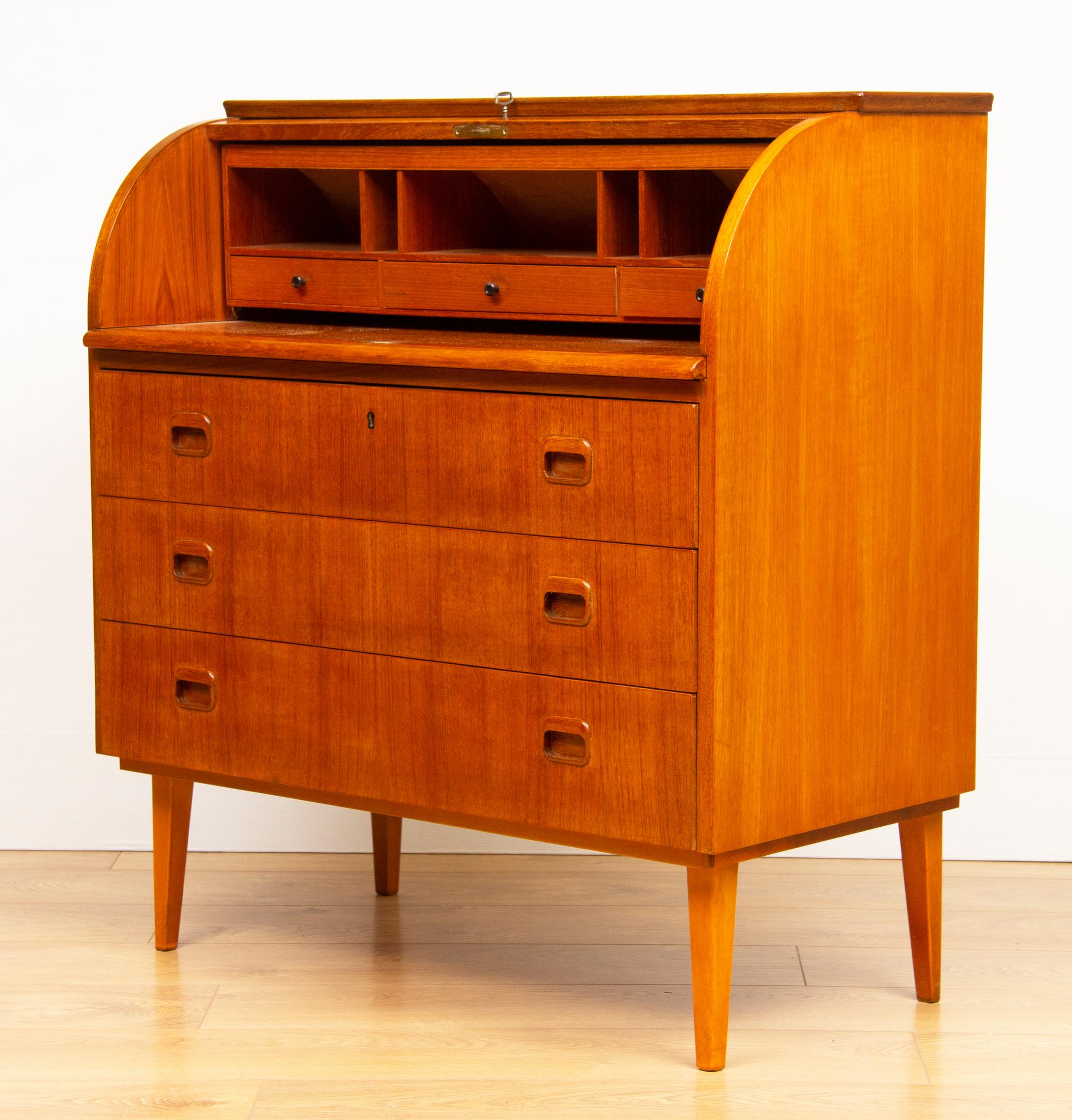 Barrel shaped roll top with quad cut veneer 
Three main section drawers with finger pull handles
Further internal drawers and pigeon holes
Pull out writing surface
Tapered legs
Original key.