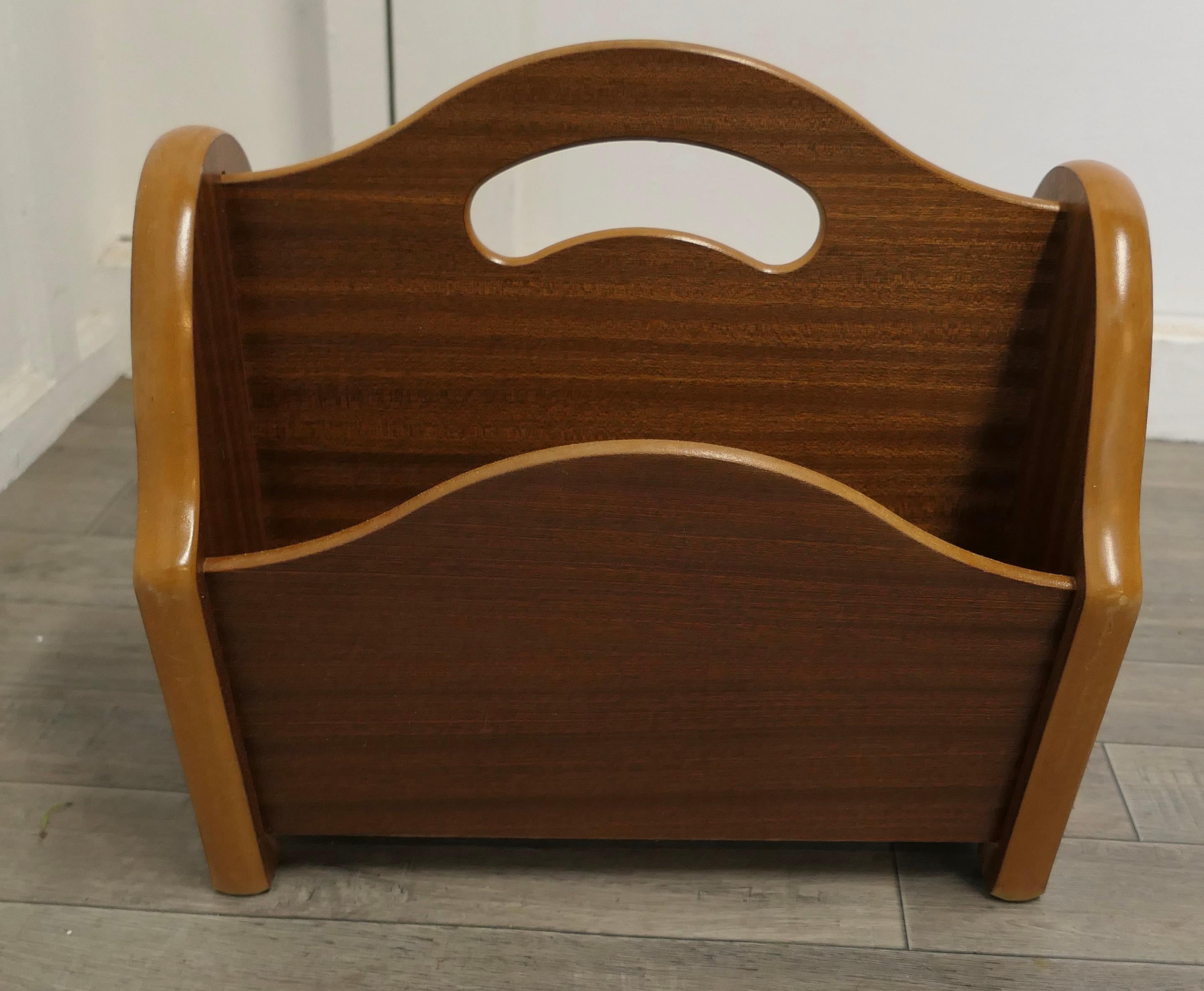 Midcentury teak canterbury or magazine rack.

This is a pretty little piece, in Teak, it has 2 magazine sections and it stands on a flat base with shaped ends and has a hand hold in the centre 
An excellent and good looking piece, it is in good