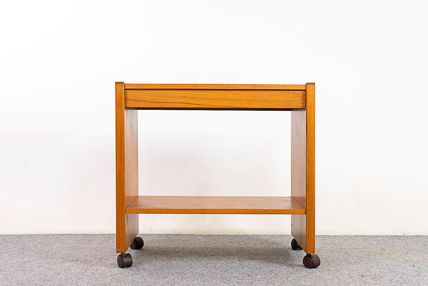 Teak rolling cart, circa 1980's. Simple, practical cart with shelf. Unrestored, as is condition with replacement caster and minor wear.