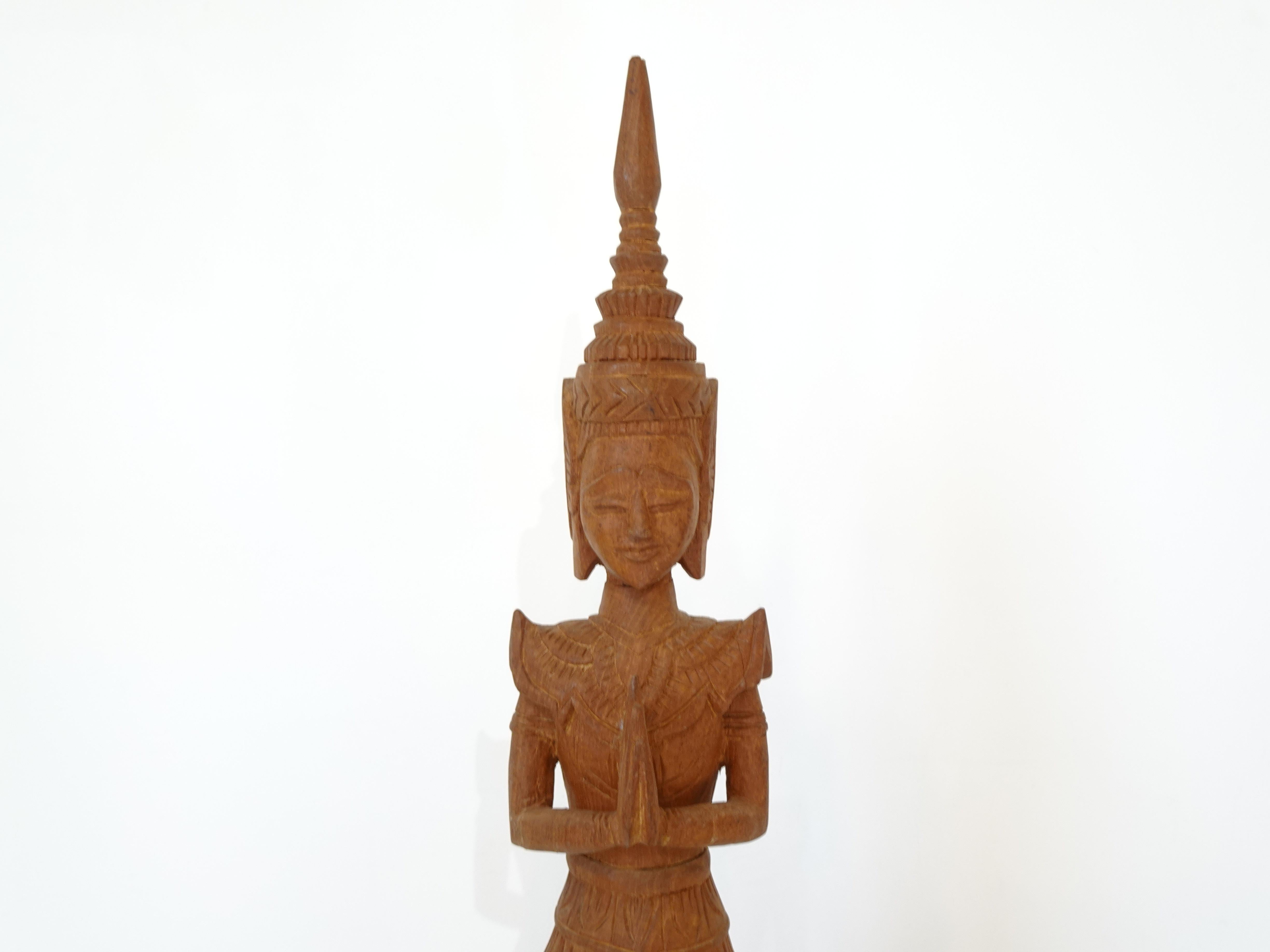 A tall hand carved teak wood Buddha in a standing restful meditative pose with nice details mounted on a white marble base . A great decorative piece for your mid century home, spa area or meditation room.