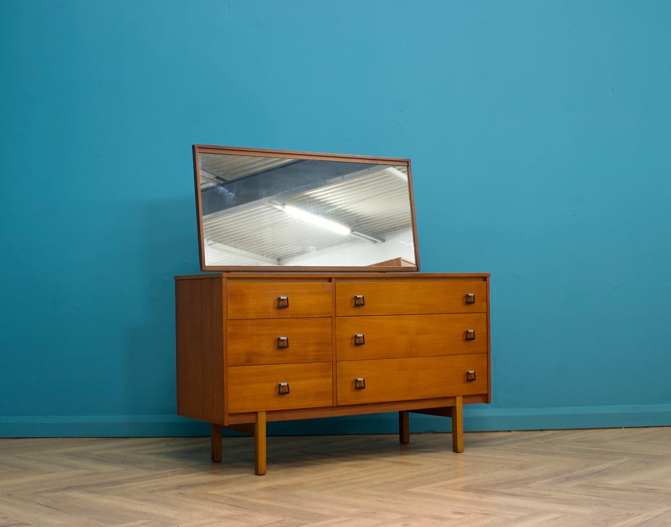 A teak chest of drawers - dressing chest from Symbol, Circa 1960s

It is long and low - so it can be used as a compact sideboard or TV unit (the mirror is easily removed)

Featuring six drawers for plenty of storage

The matching dressing chest is