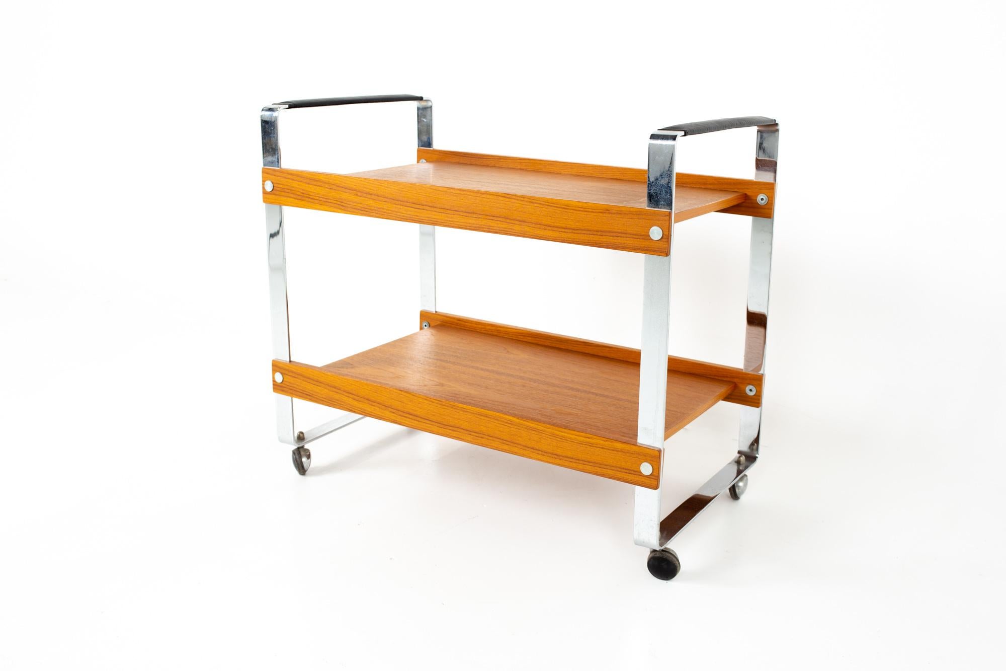 Mid century teak chrome and leather bar serving cart
Cart measures: 29.75 wide x 18.25 deep x 29.5 high

All pieces of furniture can be had in what we call restored vintage condition. That means the piece is restored upon purchase so it’s free of