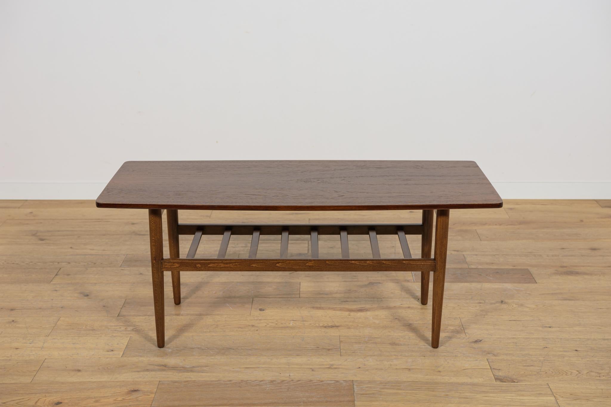 
La table basse en teck et en hêtre a été produite dans les années 1960 au Danemark. La table est dotée d'une étagère inférieure. Bois après une rénovation complète de la menuiserie, nettoyé de l'ancien revêtement, peint avec du brou de noix, fini