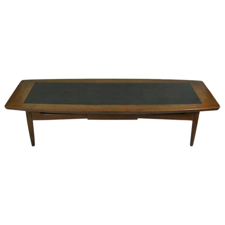 #8-362 Solid walnut  coffee table with black laminate insert and center drawer.