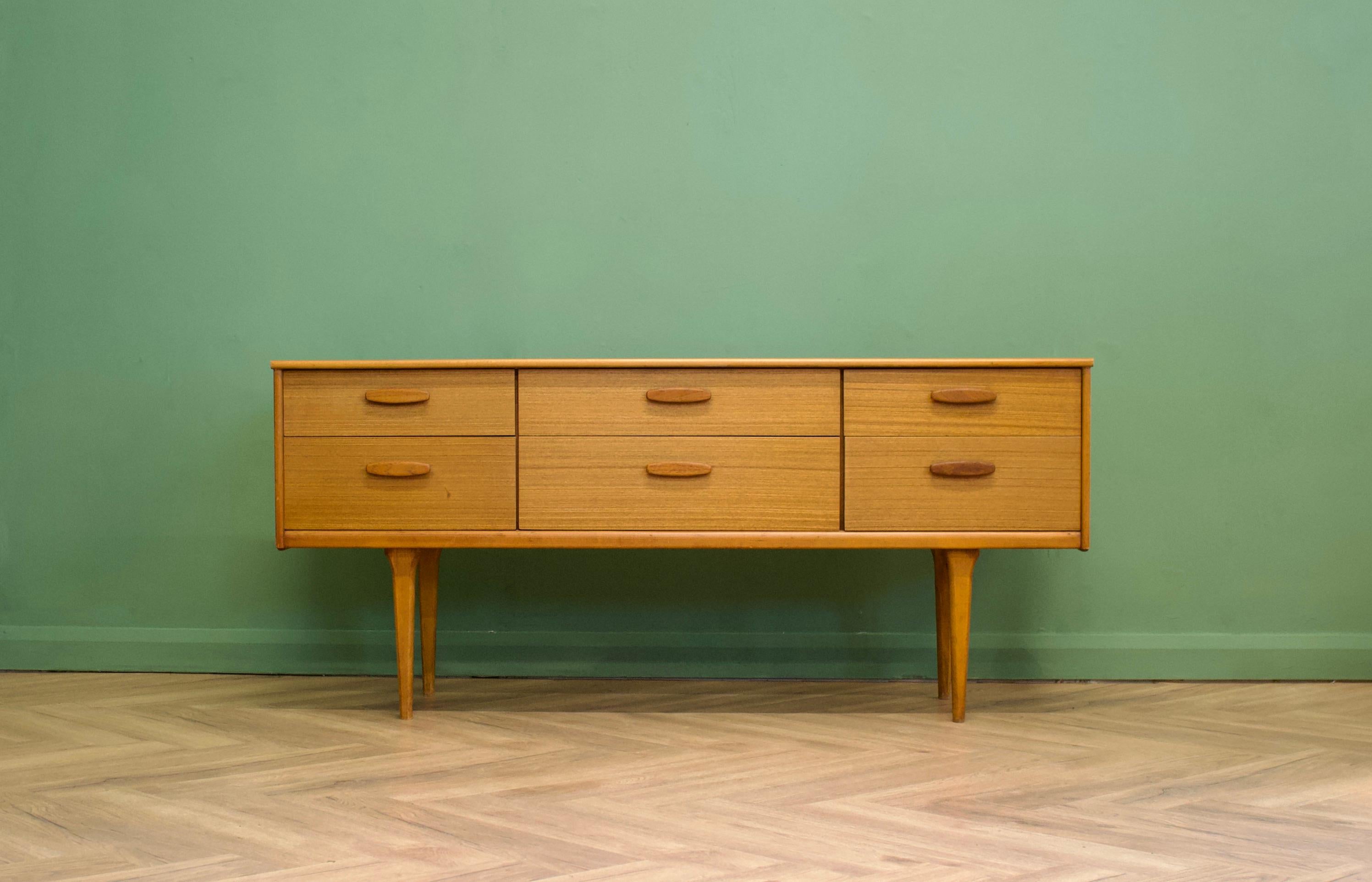 A teak long and low chest of drawers or compact sideboard from Austinsuite London- Circa 1960s

Designed by Frank Guille

It features six drawers

The piece stands on delicate tapered legs and each drawer has solid teak handles