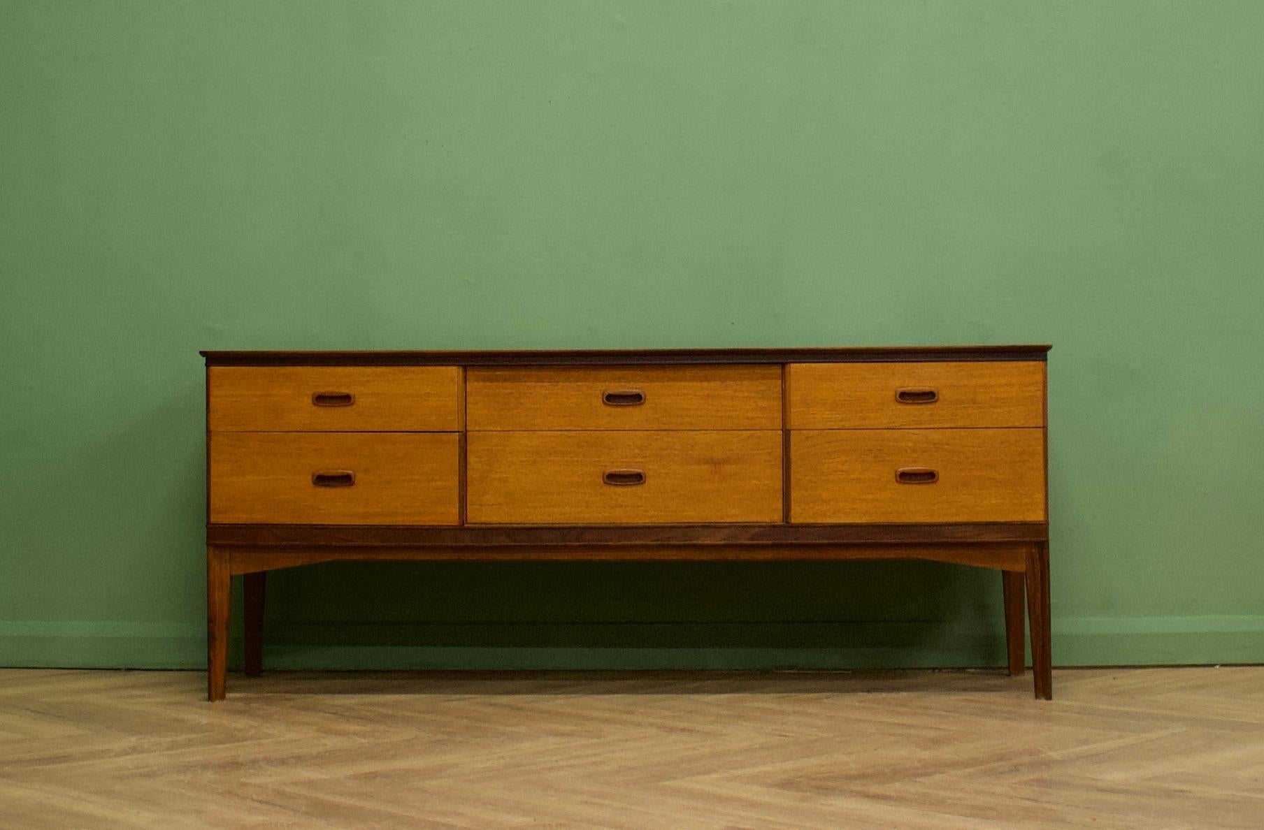 A teak long and low chest of drawers or compact sideboard from Austinsuite London- Circa 1960s

Designed by Frank Guille

It features six drawers

The piece stands on delicate tapered legs and each drawer has solid teak recessed handles