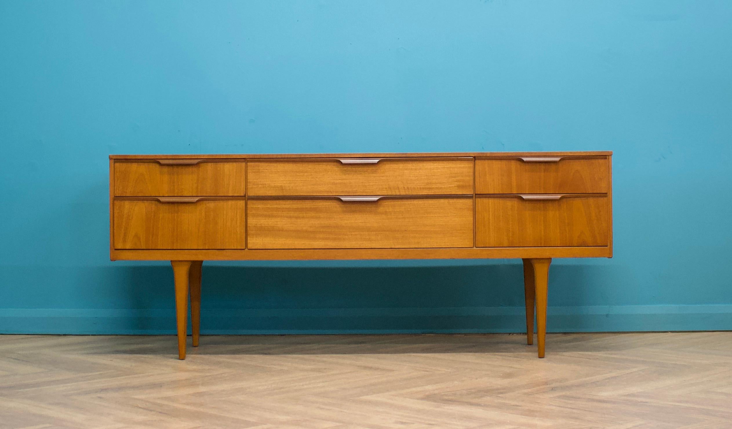 A teak compact sideboard from Austinsuite- Circa 1960s

Originally a dressing chest, this also could be used as a long low chest of drawers or a TV stand

It features six drawers and solid teak handles