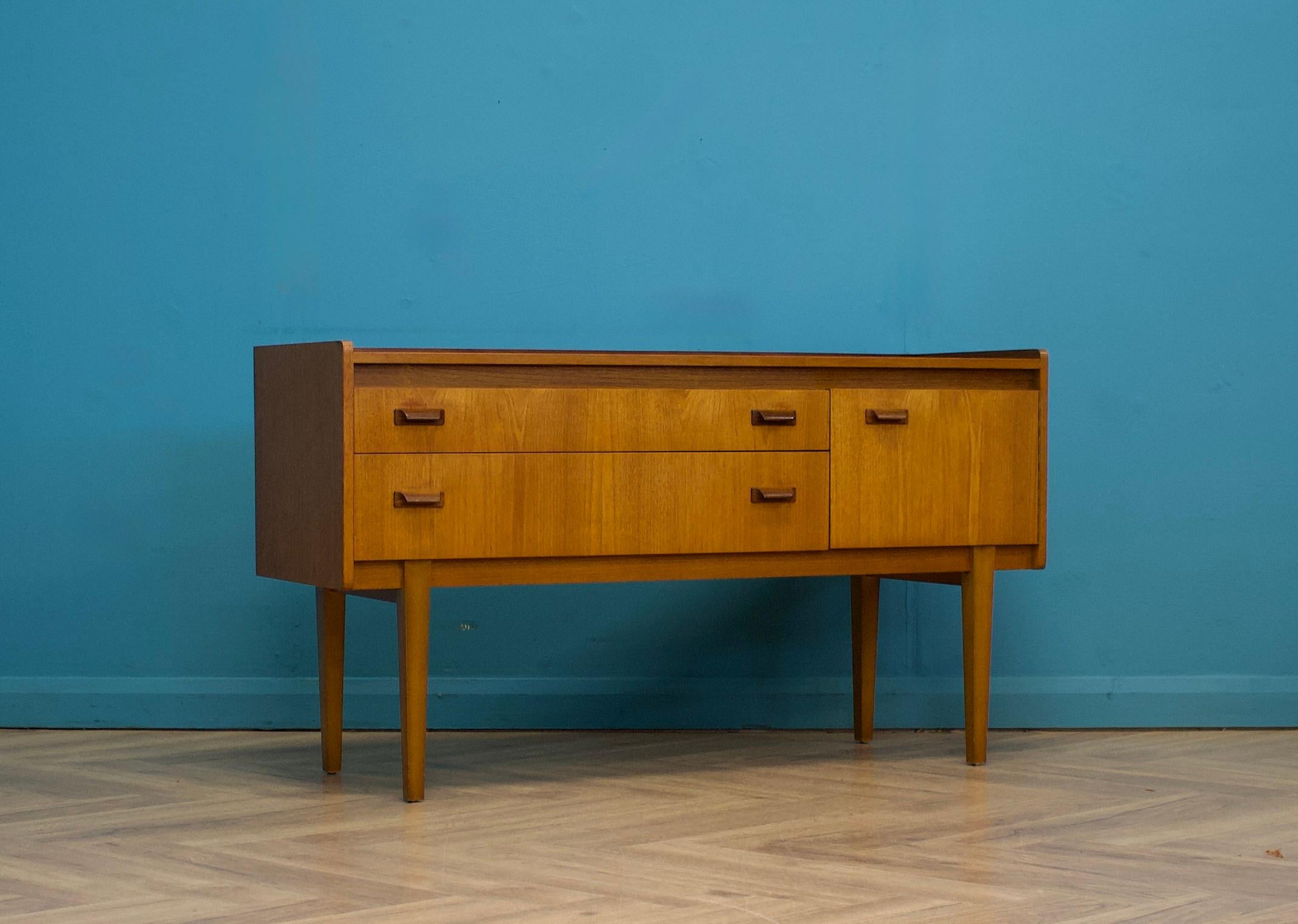 A teak compact sideboard from Wrighton - Circa 1960s

Originally a dressing chest, this also could be used as a long low chest of drawers or a TV stand

It features two drawers and a cupboard
