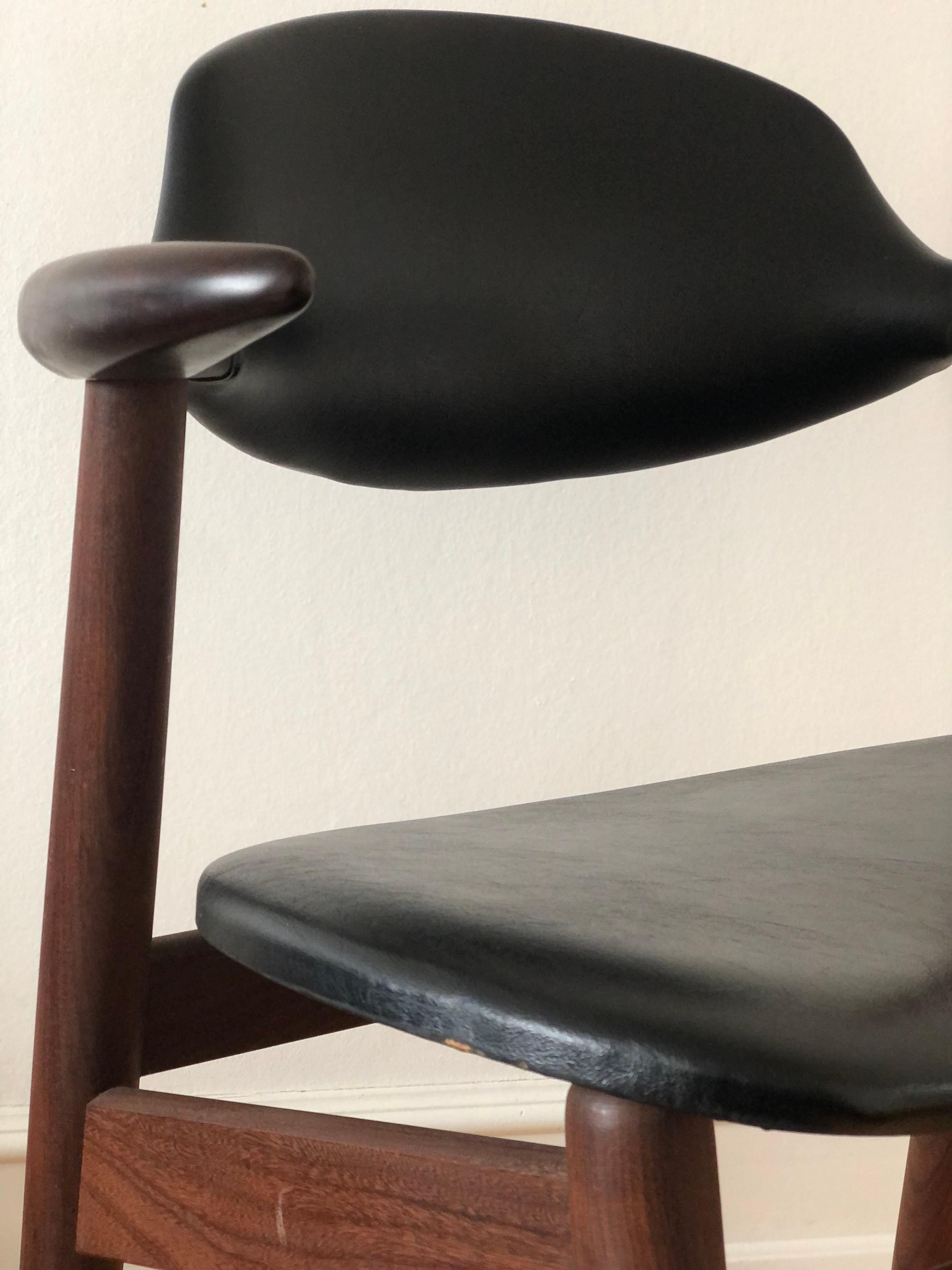 This Mid-Century cowhorn chair, designed by Tijsseling in the Netherlands during the 1960s, is a true Dutch design classic. Crafted from solid teak, the chair features armrests shaped like a cow’s horn, giving it a distinctive and elegant