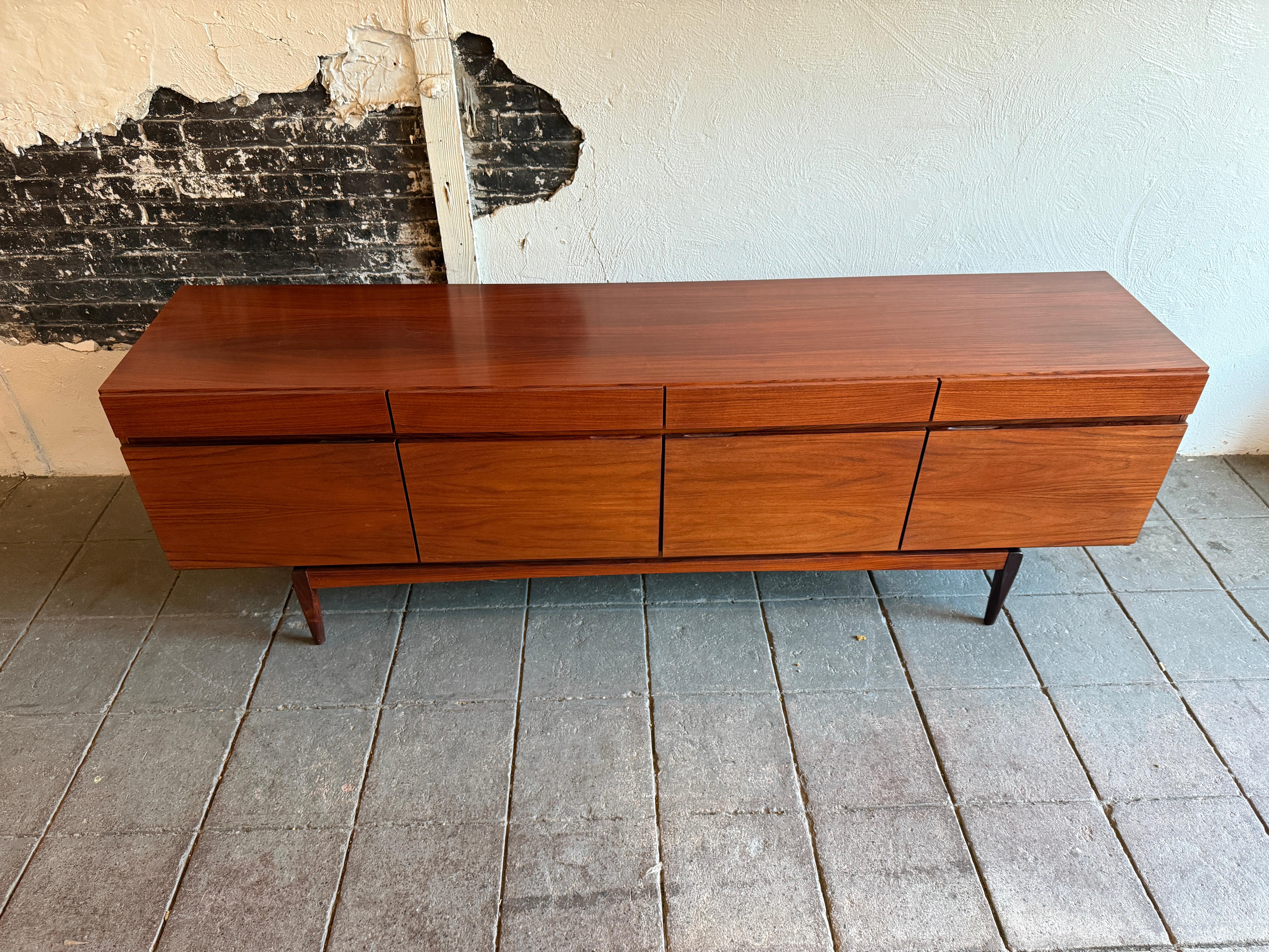 Midcentury Rosewood credenza by Ib Kofod-Larsen for Faarup Møbelfabrik Model FA66. Can be used as a credenza / sideboard / storage / media cabinet. Danish Modern design in completely original condition shows normal wear and use. Beautiful reddish
