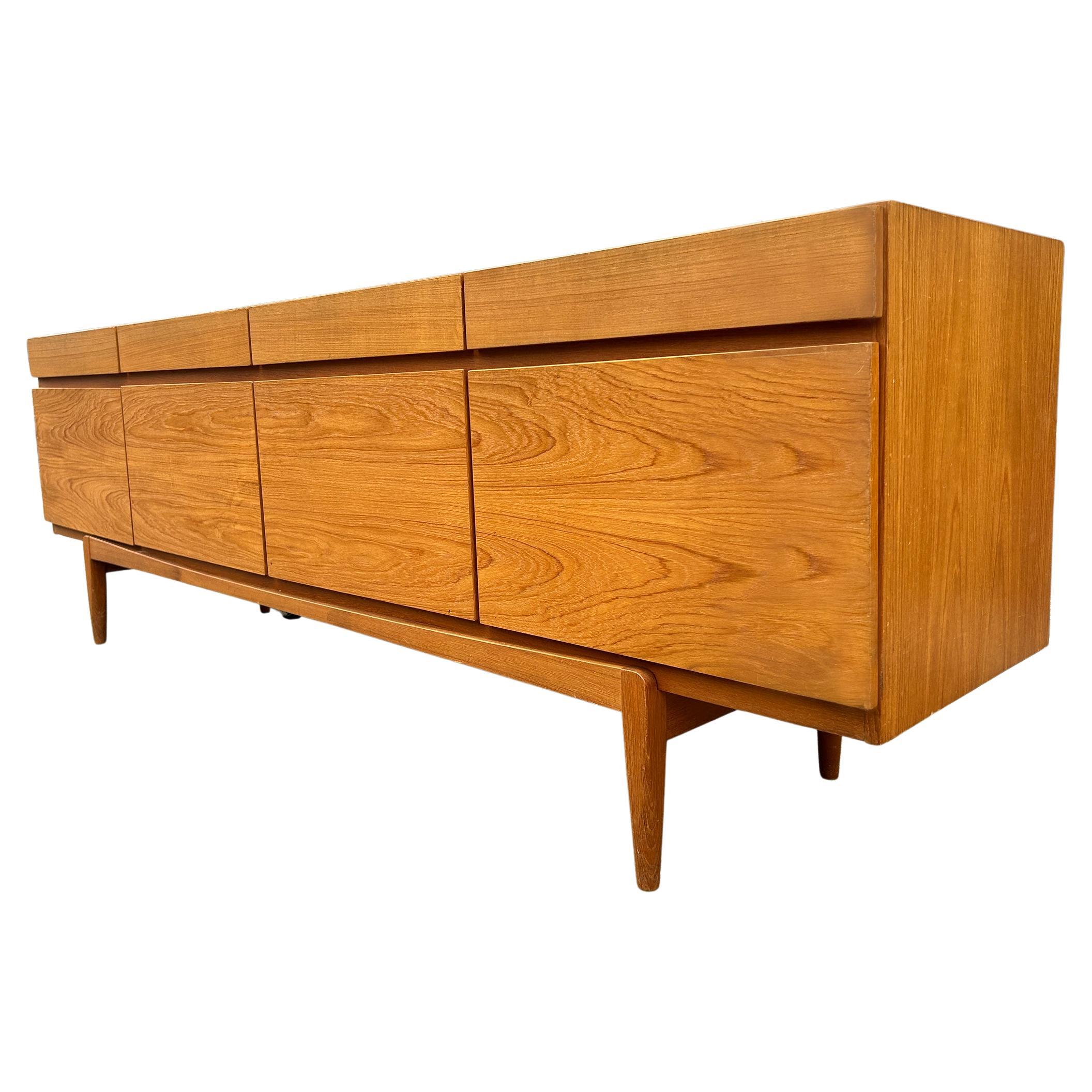 Midcentury teak credenza by Ib Kofod-Larsen for Faarup Møbelfabrik Model FA66. Can be used as a credenza / sideboard / storage / media cabinet. Danish Modern design in completely original condition shows normal wear and use. Beautiful light teak