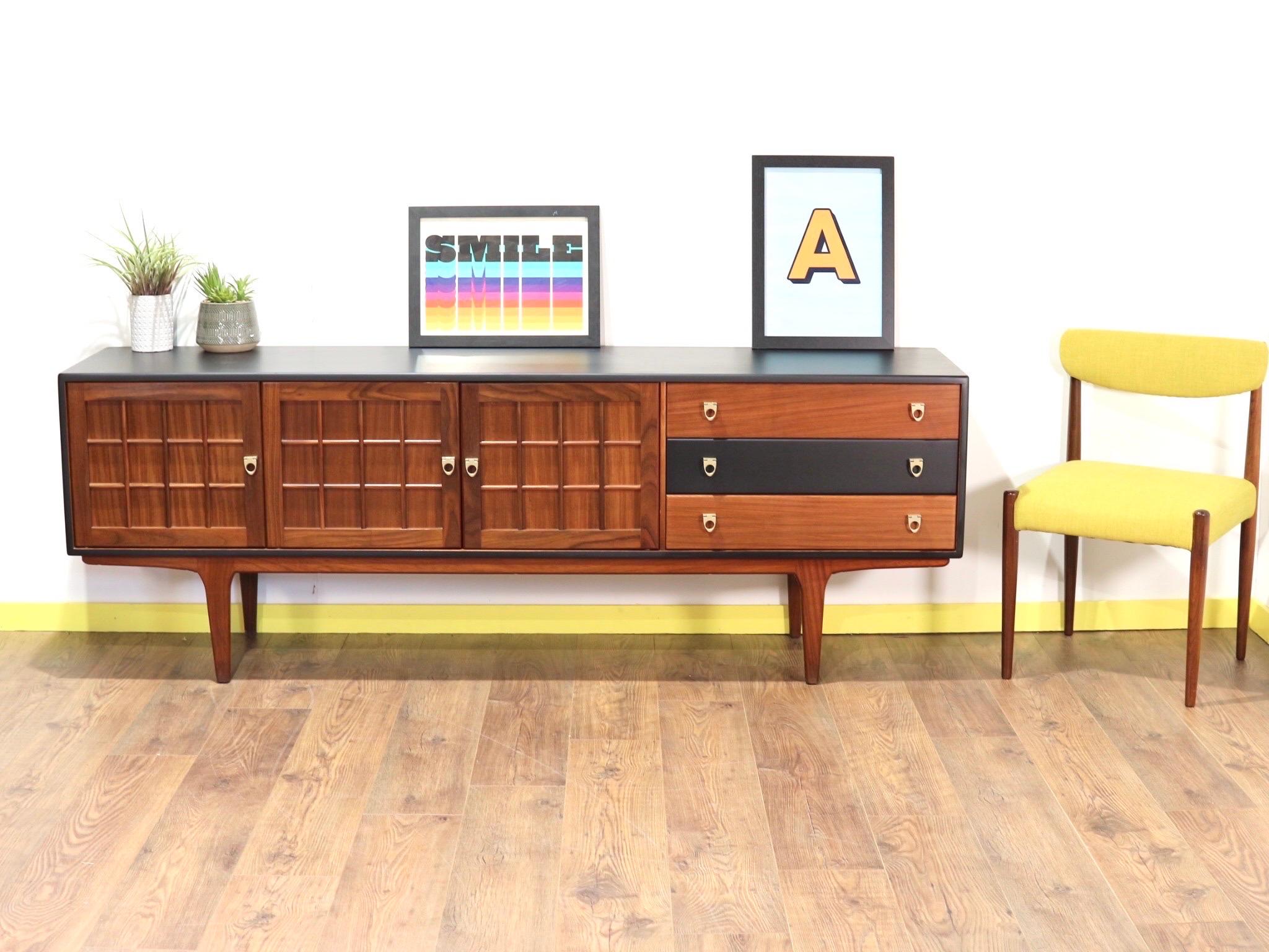 This is a beautiful and unusual teak sideboard from A.Younger dating from mid 1960s. The Jacobean-style paneling on doors makes this sideboard stand out from the crowd as well as the black outer colour. Comprising of three drawers with the top