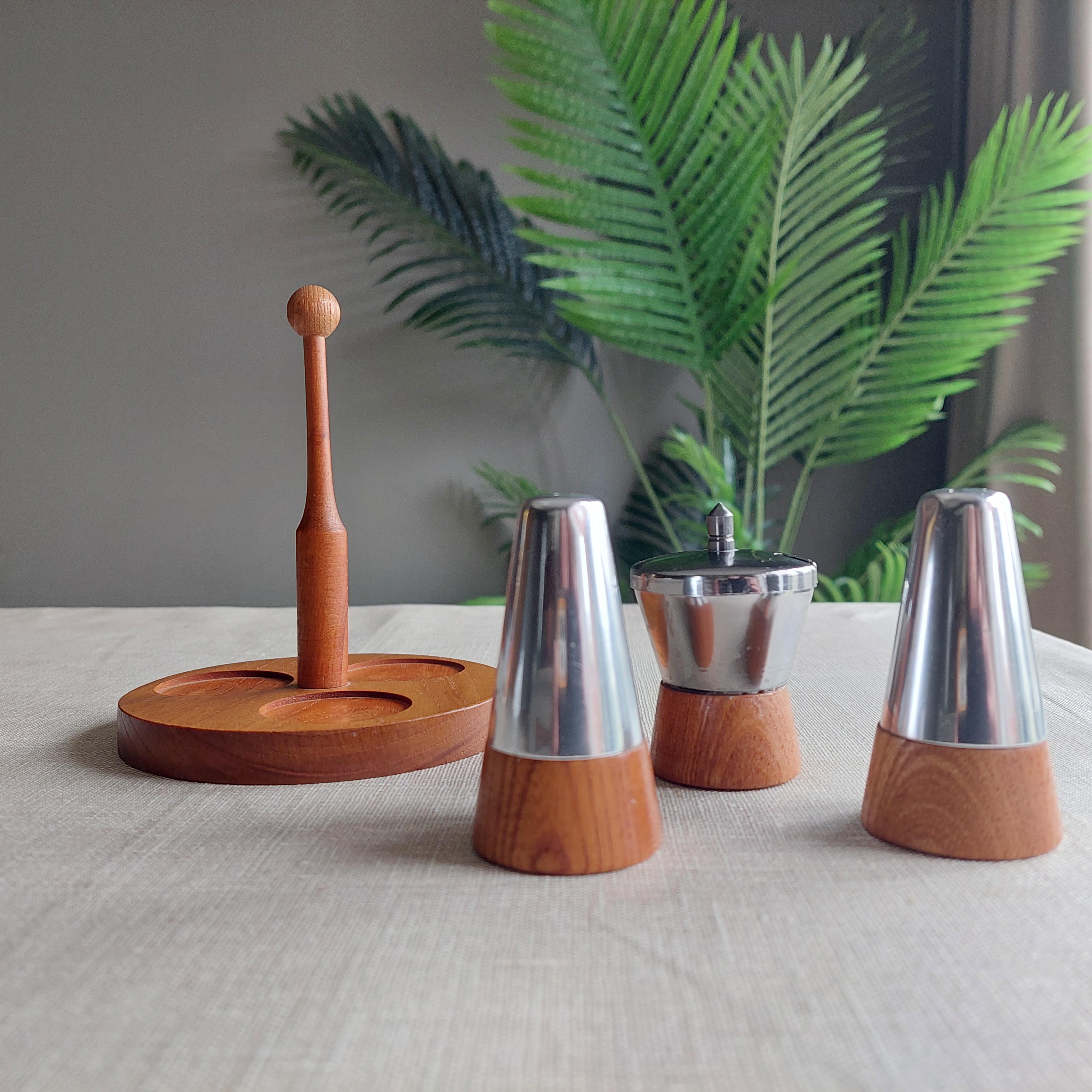 Mid-Century teak and metal cruet set (Danish/Scandinavian)
Stamped Foreign underneath, so most probably from Germany
Circa 1960s

Comprising of a tray/ holder salt and pepper shakers and a mustard or pot  with lid.
Made of teak and silver coloured