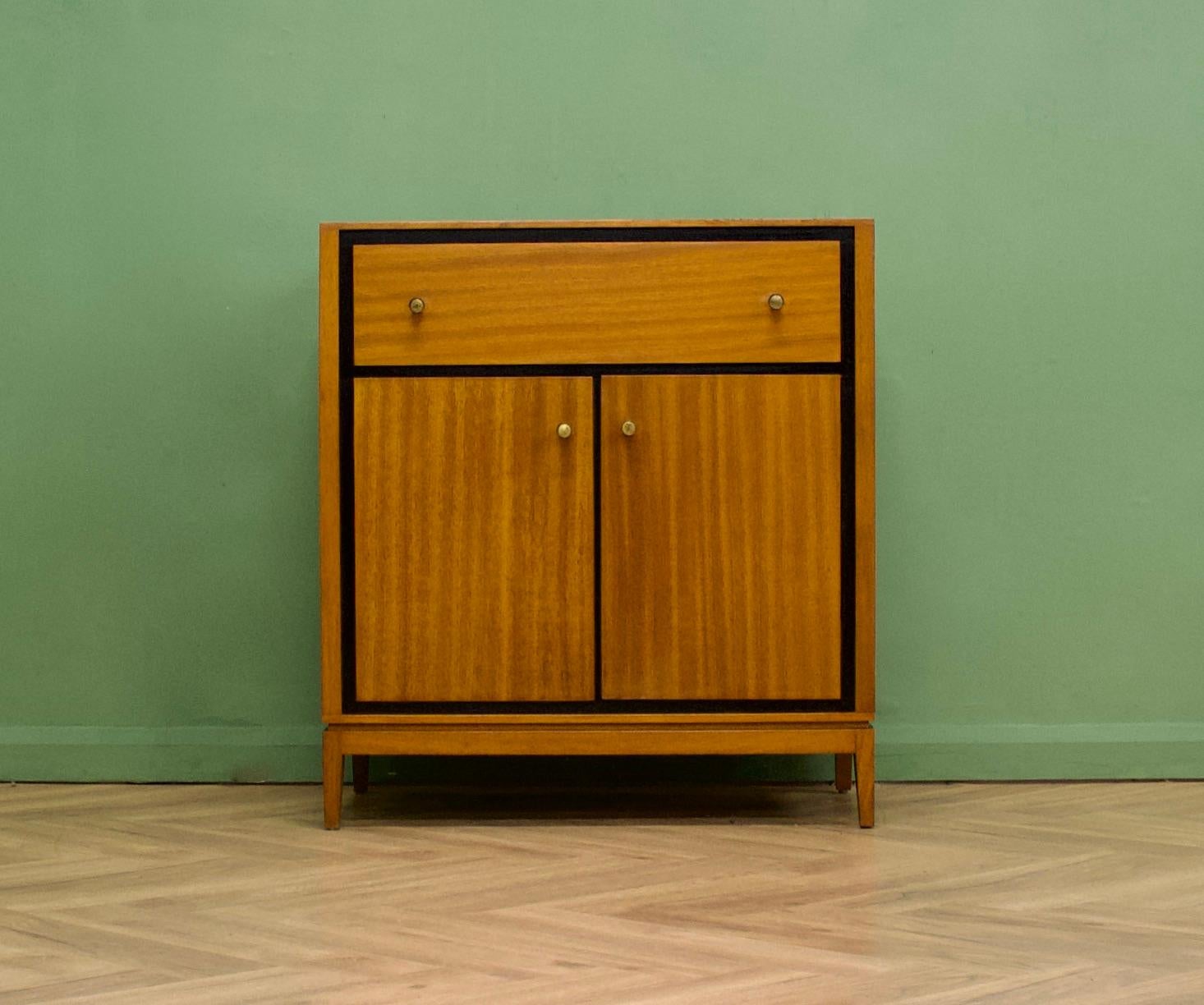 A teak & mahogany compact sideboard or cupboard from Loughborough Furniture - retailed through Heals during the 1950s
With an ebonised trim
Featuring a drawer to the top and a cupboard - with an internal shelf