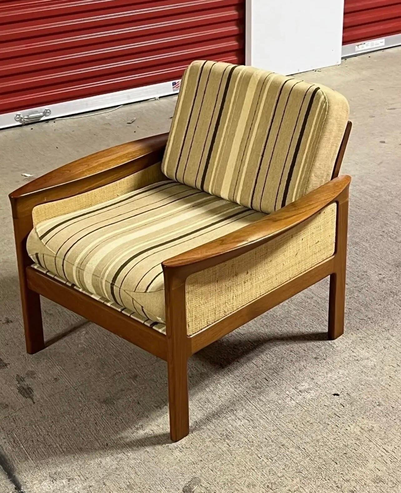 This lounge chair is available for purchase. It is a beautiful mid-century piece crafted from teak wood. The chair is of Danish origin and was made by Komfort. You will find the brand tag marking underneath the chair