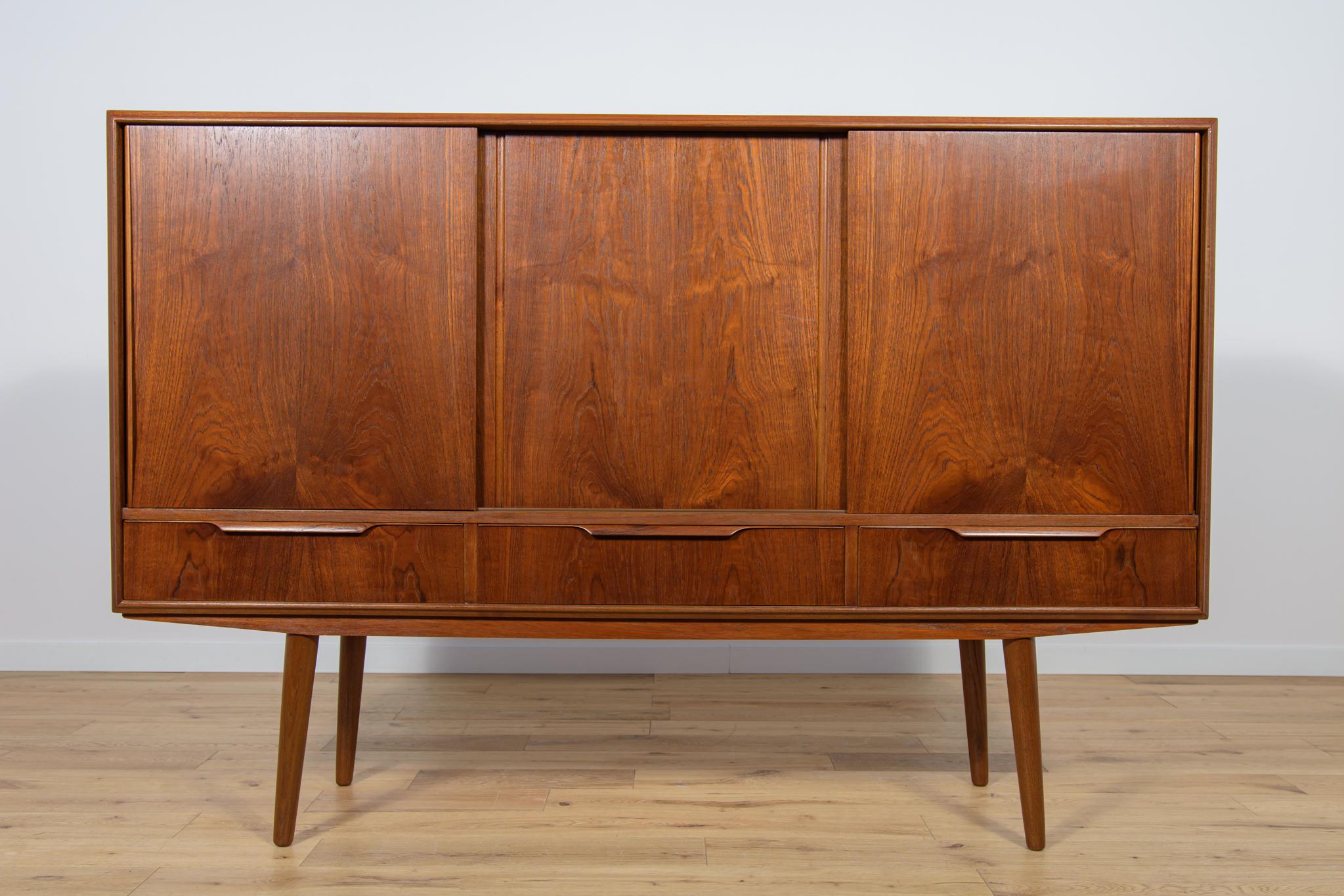 Danish sideboard in teak designed by EW Bach for Sejling Skabe in the 60s. The chest of drawers has three drawers at the bottom and three sliding doors at the top. In the upper part there are shelves, a bar and two drawers. The teak elements have