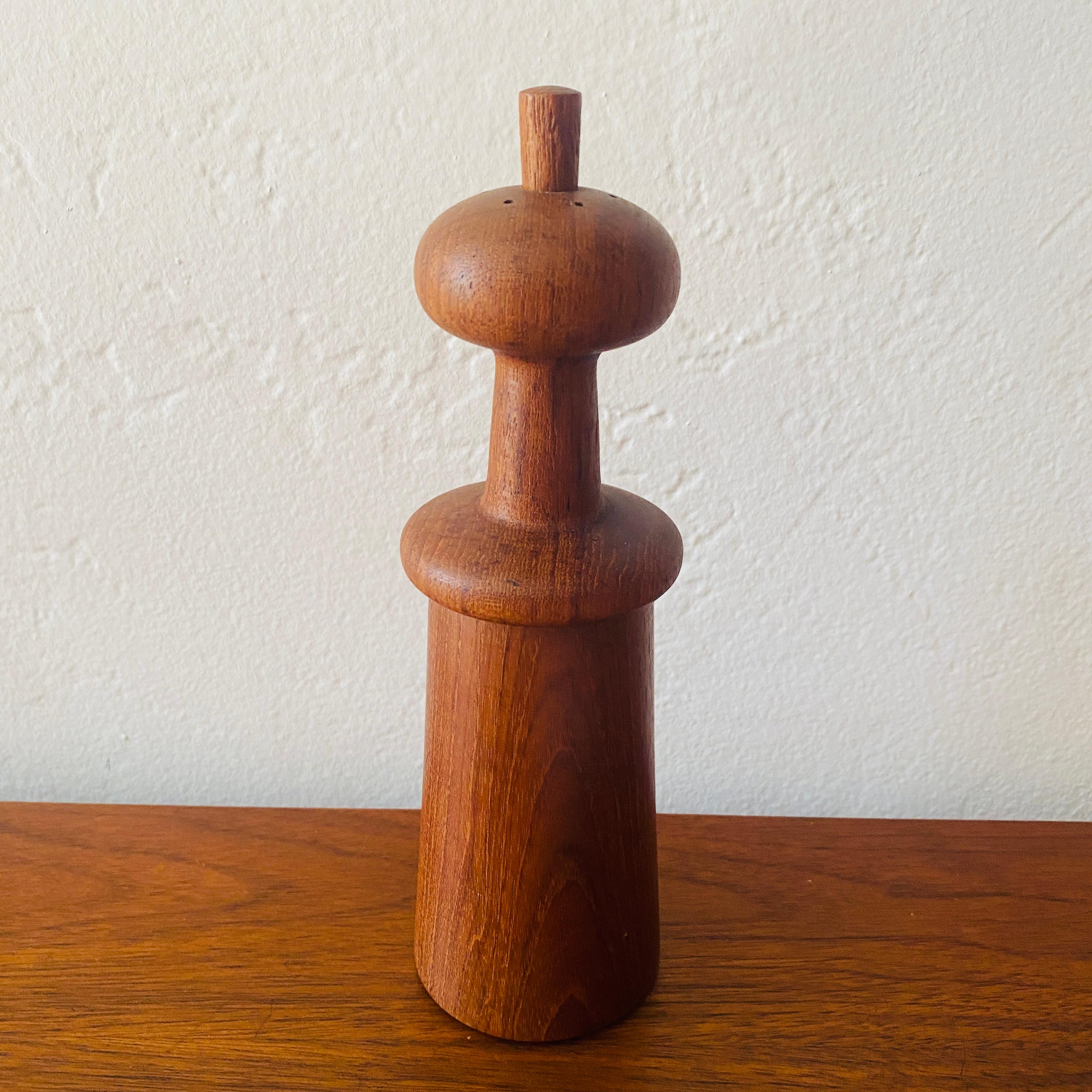 This is a mid-century modern sculptural salt and pepper mill in teak designed by Jens Harald Quistgaard for Dansk Designs. This piece features a mushroom-shaped top with a removable peg for filling salt. Includes a pepper grinding mechanism on the