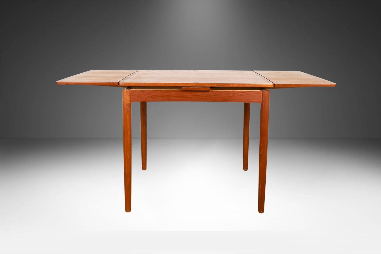 An exceptional, Danish, Modern, teak draw leaf Expandable game dining table, by Hundevad & Co., made in Denmark. With an initial small footprint, this table can also offer a generous space and double in size once its hidden draw leaves are extended.
